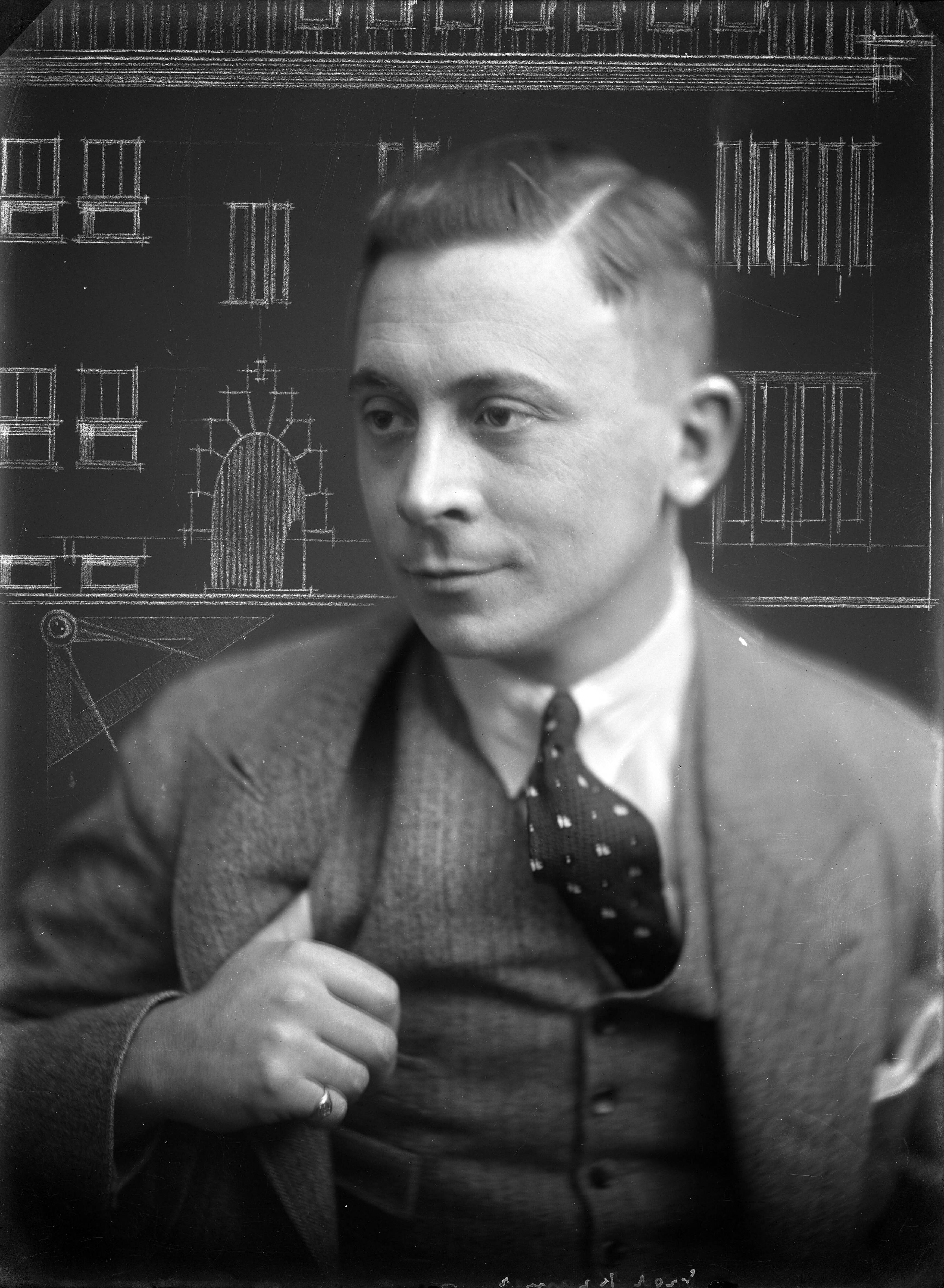 Portretten — Studio-opnames. Portret van man in driedelig pak met opgeschoren kapsel voor een architectuurtekening. Aan bovenkant op glasnegatief: 9427 G.J. van Waveren gravure. Haarlem, Nederland 1918-1930. — Foto: Berg, Th.C.J. van den / Spaarnestad Photo (05887). Licentie: Set B: Rechtenvrij / Publiek Domein. Bron: Nationaal Archief. http://hdl.handle.net/10648/35429da7-c54c-a382-e063-6df0900a6686