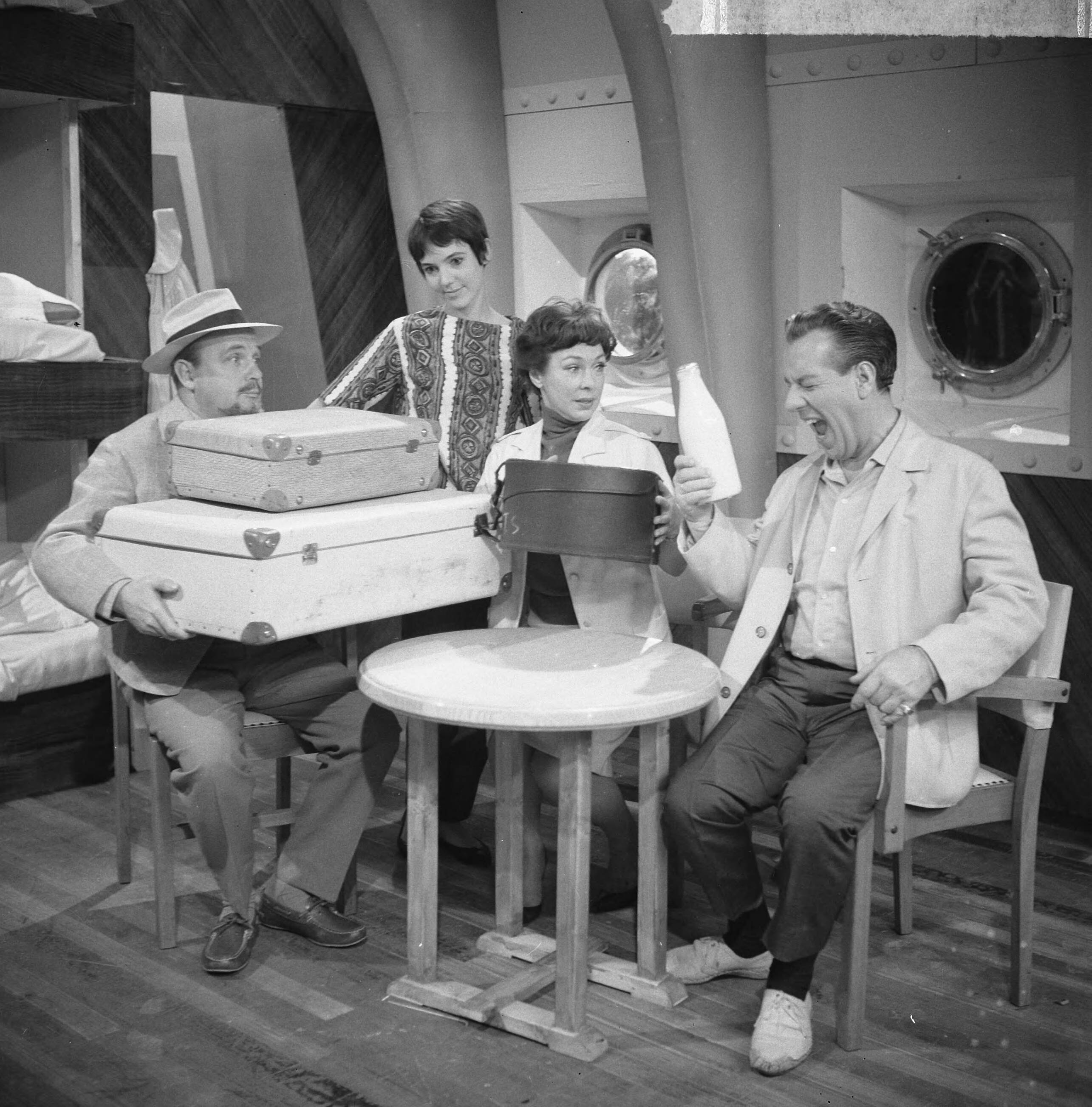 Fotocollectie Anefo — Opname televisiespel "Met 24 pk door Europa" (uitzending niet doorgegaan), vlnr. Guus Verstraete jr. , Simone Rooskens, Teddy Schaank en Ko van DijkNegatieven zijn een jaar later, op 31-3-1964, geregistreerd in fotoadministratie Anefo! Deze aflevering is wél uitgezonden, als eerste op 20-10-1963. Op 22-11-1963 schrijft Trouw: Er komen geen afleveringen meer van de televisiestrip "Met 24 P.K. door Europa" met Ko van Dijk, Teddy Schaank en Simone Rooskens. De AVRO heeft besloten de serie te staken. Reden: de strip kon ook na bewerking van het oorspronkelijke script niet aan de gestelde eisen voldoen. Karel Prior, hoofd amusementsprogramma's van de AVRO zei van deze door het echtpaar Mazure geschreven strip, dat ze „te filmisch" waren geschreven, waardoor men er in de televisiestudio's niet goed mee uit de voeten kon. Ellen en Georges Mazure, die zes afleveringen van hun strip aan de AVRO verkochten, liggen al een poosje overhoop met de AVRO in verband met de televis