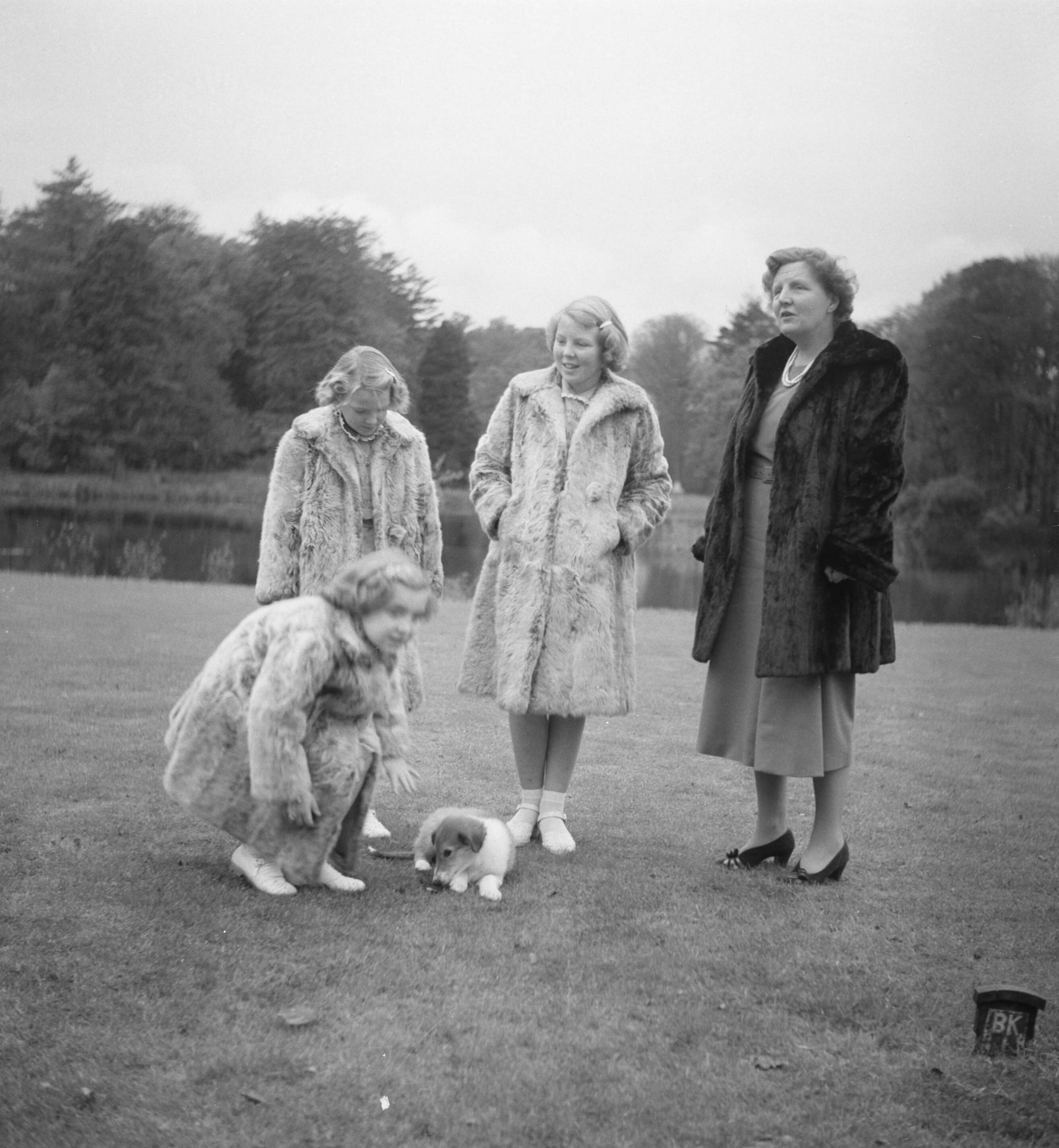 Reportage Koninklijk gezin op paleis Soestdijk — Koninklijk gezin op Soestdijk. Vlnr. prinses Margriet, prinses Irene, prinses Beatrix en koningin Juliana. Op het gazon een hondje — Foto: Noske, J.D. / Anefo. Licentie: Set B: Rechtenvrij / Publiek Domein. Bron: Nationaal Archief. http://hdl.handle.net/10648/a8e1b6b6-d0b4-102d-bcf8-003048976d84