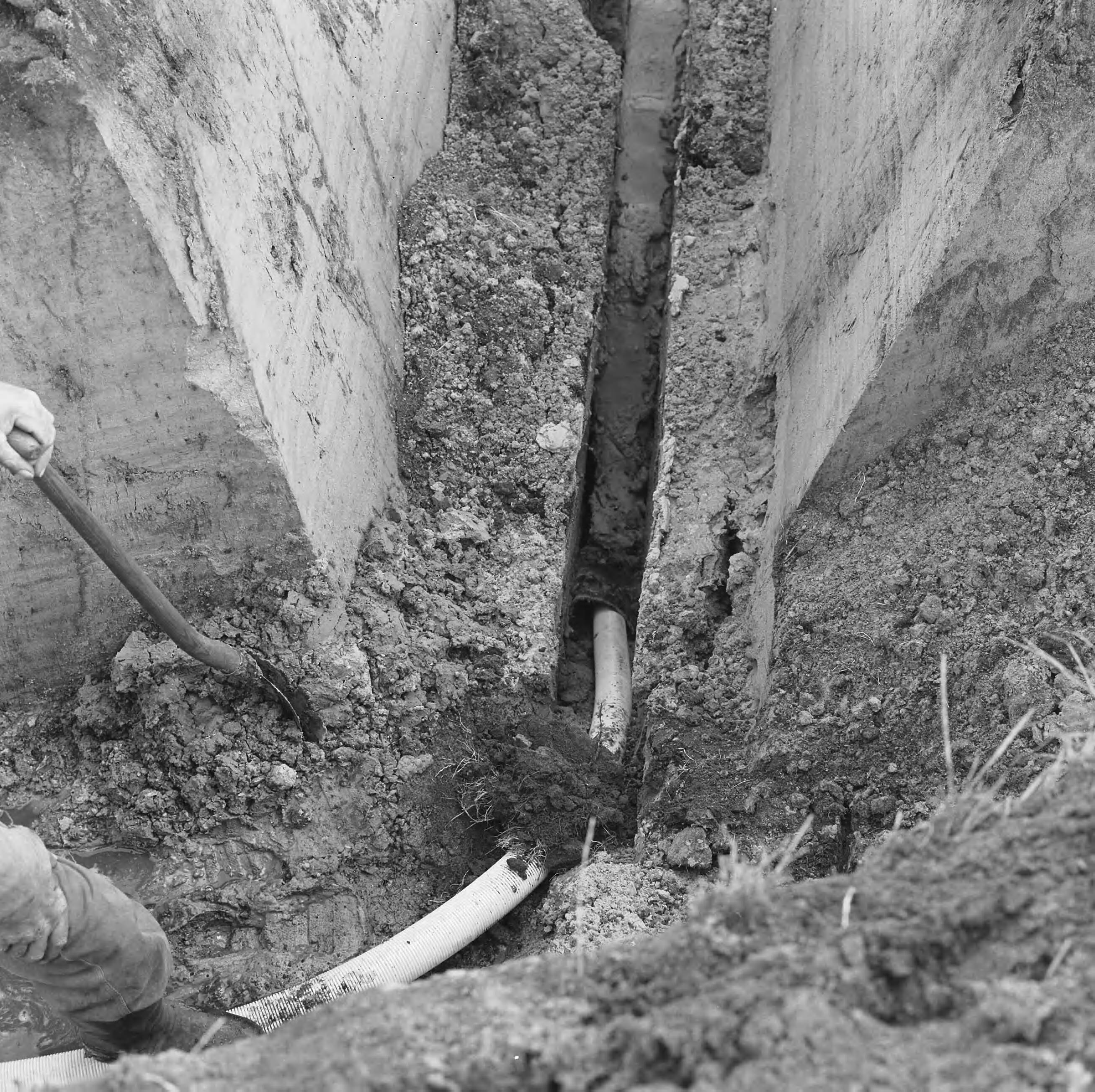 Fotocollectie Nederlandse Heidemaatschappij — Horizontale bronbemaling hoofdaardgastransportleiding Tusschenklappen-Balkbrug. De diepgraver bij de inzet de gegraven sleuf van 0,18 wordt geheel gevuld door de geleide pijp, waarder de filterbuis in de grond wordt gebracht. Het gedeelte boven de volle sleufdiepte van 3.50 m. betaat uit blinde filterbuis, daarna wordt overgegan op geperforeerde buis — Foto: Wüllschleger, [...] / Heidemij. Licentie: Set B: Rechtenvrij / Publiek Domein. Bron: Nationaal Archief. http://hdl.handle.net/10648/ae811c1a-d0b4-102d-bcf8-003048976d84
