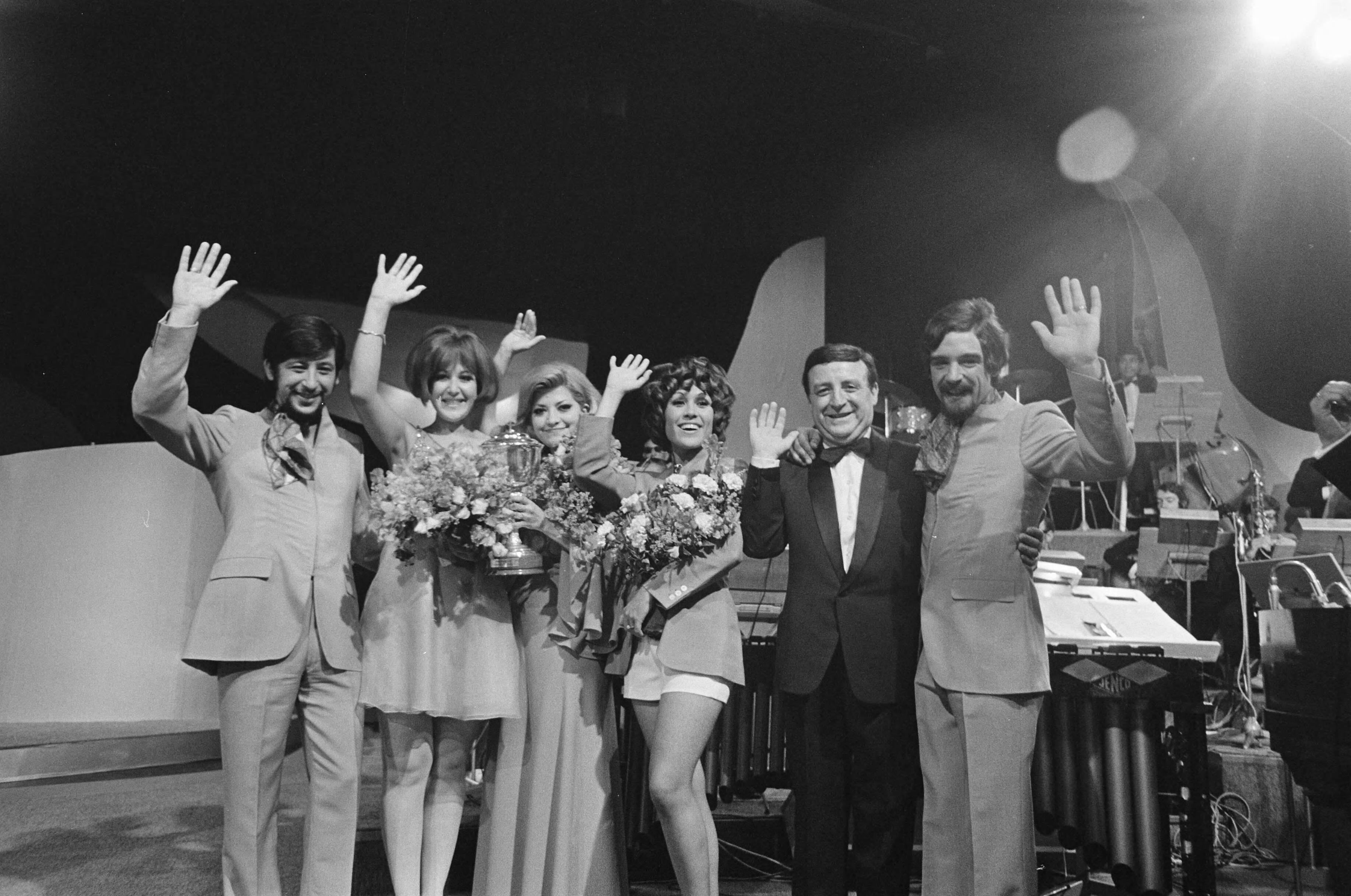 Singing Europe 1969, de finale in Scheveningen — Gelukkige Spaanse ploeg met de beker met o.a. de groep Los Mismos, de zangeressen Christina en Conchita Bautista, en de zanger F. Figueras — Foto: Fotograaf Onbekend / Anefo. Licentie: Set B: Rechtenvrij / Publiek Domein. Bron: Nationaal Archief. http://hdl.handle.net/10648/ab7235c2-d0b4-102d-bcf8-003048976d84