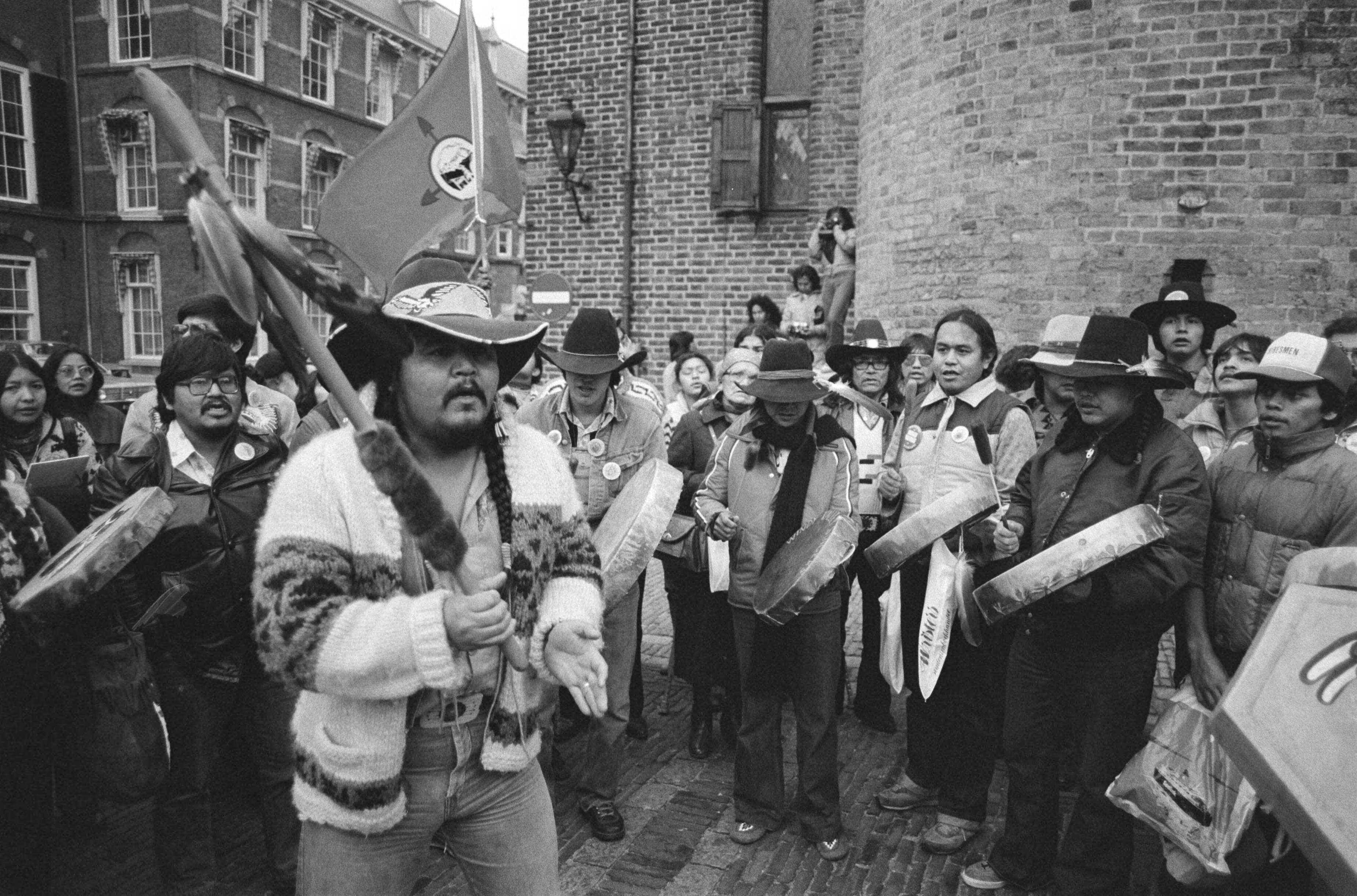 Groep Canadese Indianen demonstreert op het Binnenhof in Den Haag, teneinde aandacht te verkrijgen voor de situatie in hun land — Indianen demonstreren op het Binnenhof — Foto: Antonisse, Marcel / Anefo. Licentie: Set B: Rechtenvrij / Publiek Domein. Bron: Nationaal Archief. http://hdl.handle.net/10648/ad08926e-d0b4-102d-bcf8-003048976d84