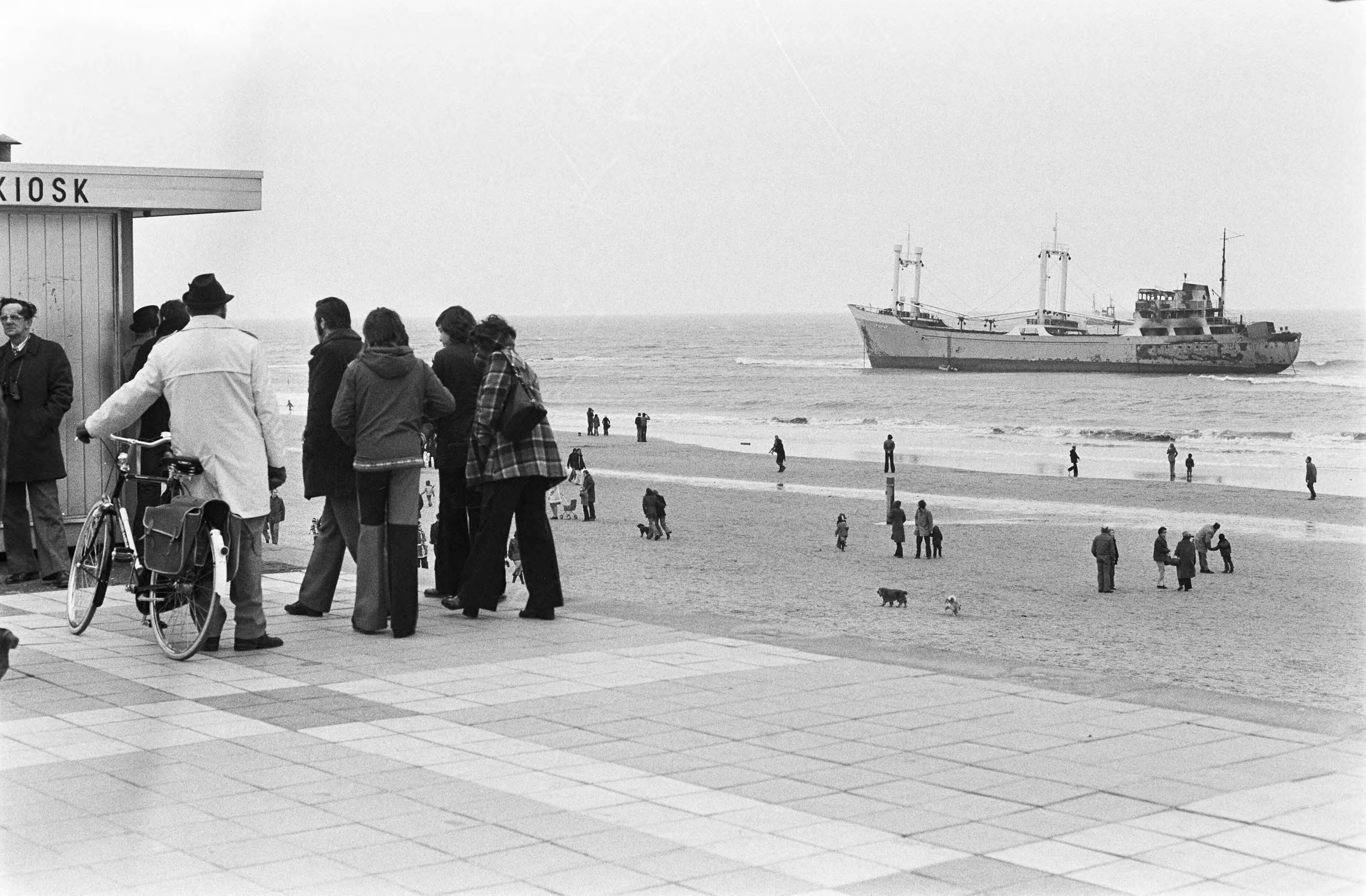 Fotocollectie Anefo — Belangstellenden op strand in Scheveningen kijken naar gestrande coaster — Foto: Peters, Hans / Anefo. Licentie: Set B: Rechtenvrij / Publiek Domein. Bron: Nationaal Archief. http://hdl.handle.net/10648/ac5dae4e-d0b4-102d-bcf8-003048976d84