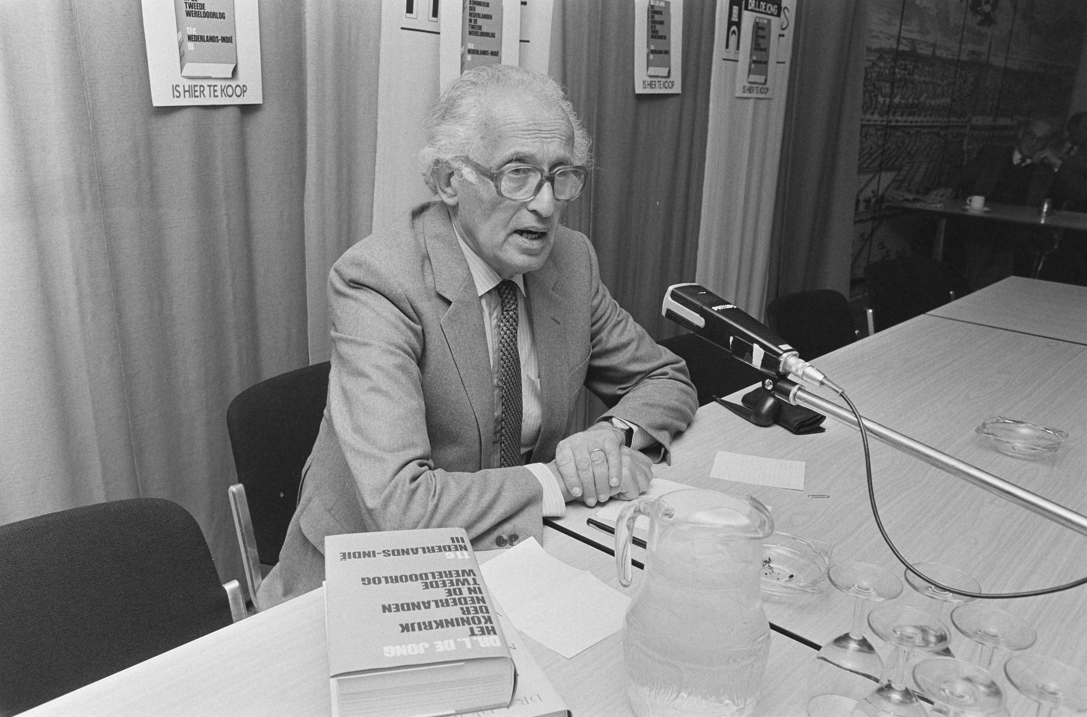 Fotocollectie Anefo — Dr. L. de Jong presenteert in Den Haag deel 11c van "Het Koninkrijk der Nederlanden in de Tweede Wereldoorlog dr. L. de Jong tijdens de presentatie / — Foto: Gerrits, Roland / Anefo. Licentie: Set B: Rechtenvrij / Publiek Domein. Bron: Nationaal Archief. http://hdl.handle.net/10648/ad58a394-d0b4-102d-bcf8-003048976d84
