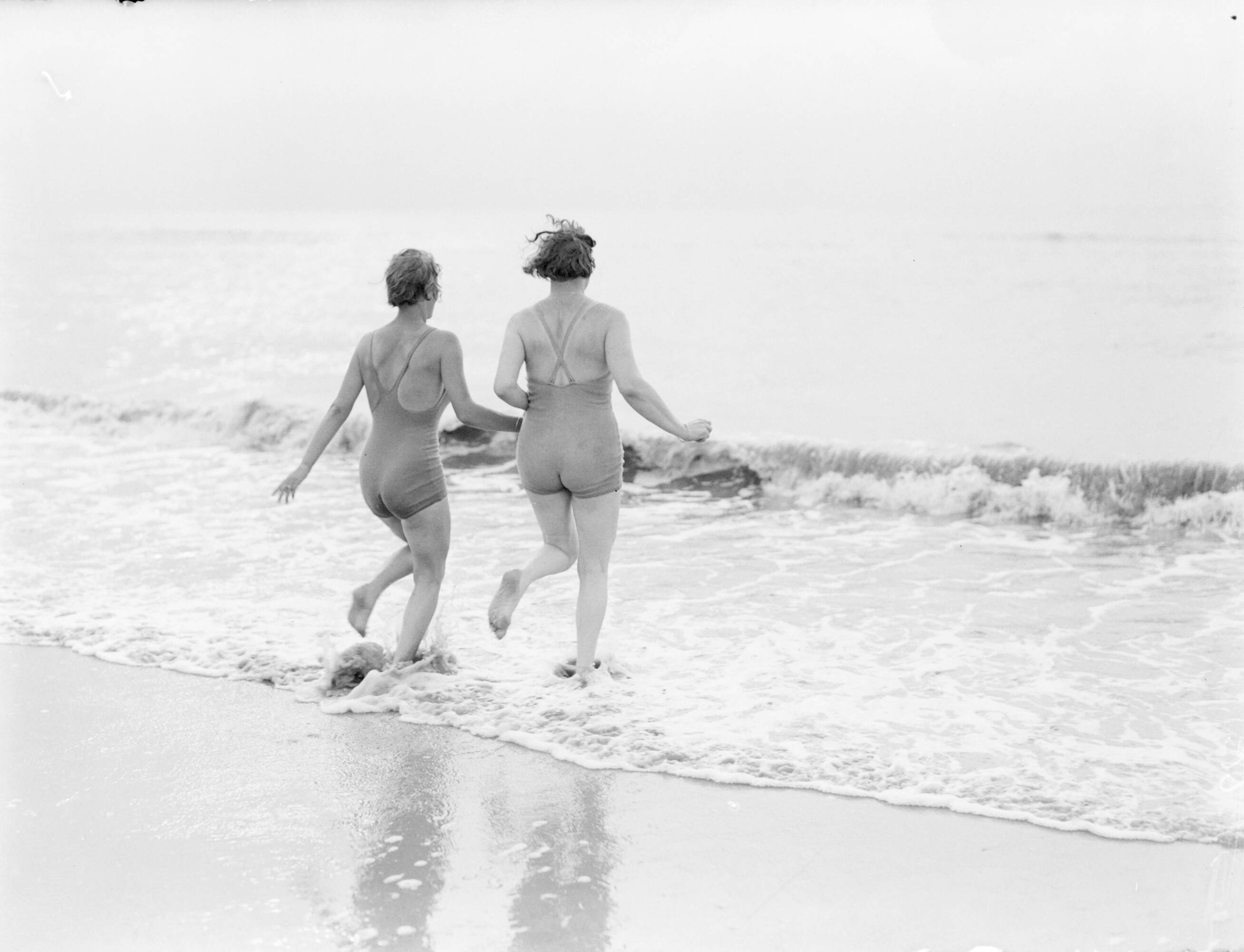 Reportage fotomodel — Van de Polls vrouw Nell Langlais (rechts) en Eva Waldschmidt rennen de zee in bij Zandvoort — Foto: Poll, Willem van de. Licentie: Set B: Rechtenvrij / Publiek Domein. Bron: Nationaal Archief. http://hdl.handle.net/10648/aea805dc-d0b4-102d-bcf8-003048976d84