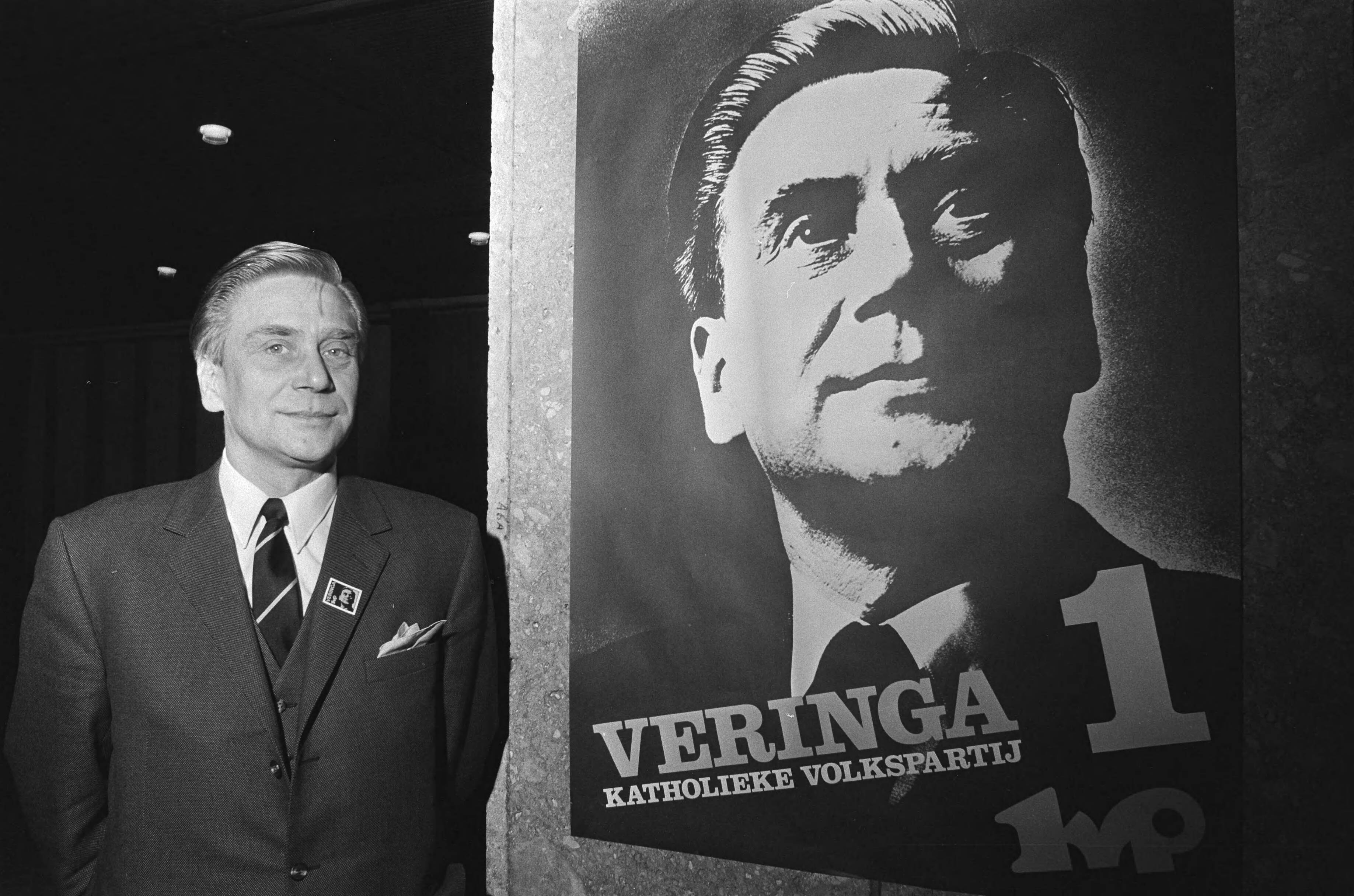 Partijraad van de KVP in Turfschip Breda over samenwerking met de VVD — Gerard Veringa voor het verkiezingsaffiche — Foto: Fotograaf Onbekend / Anefo. Licentie: Set B: Rechtenvrij / Publiek Domein. Bron: Nationaal Archief. http://hdl.handle.net/10648/abb90542-d0b4-102d-bcf8-003048976d84