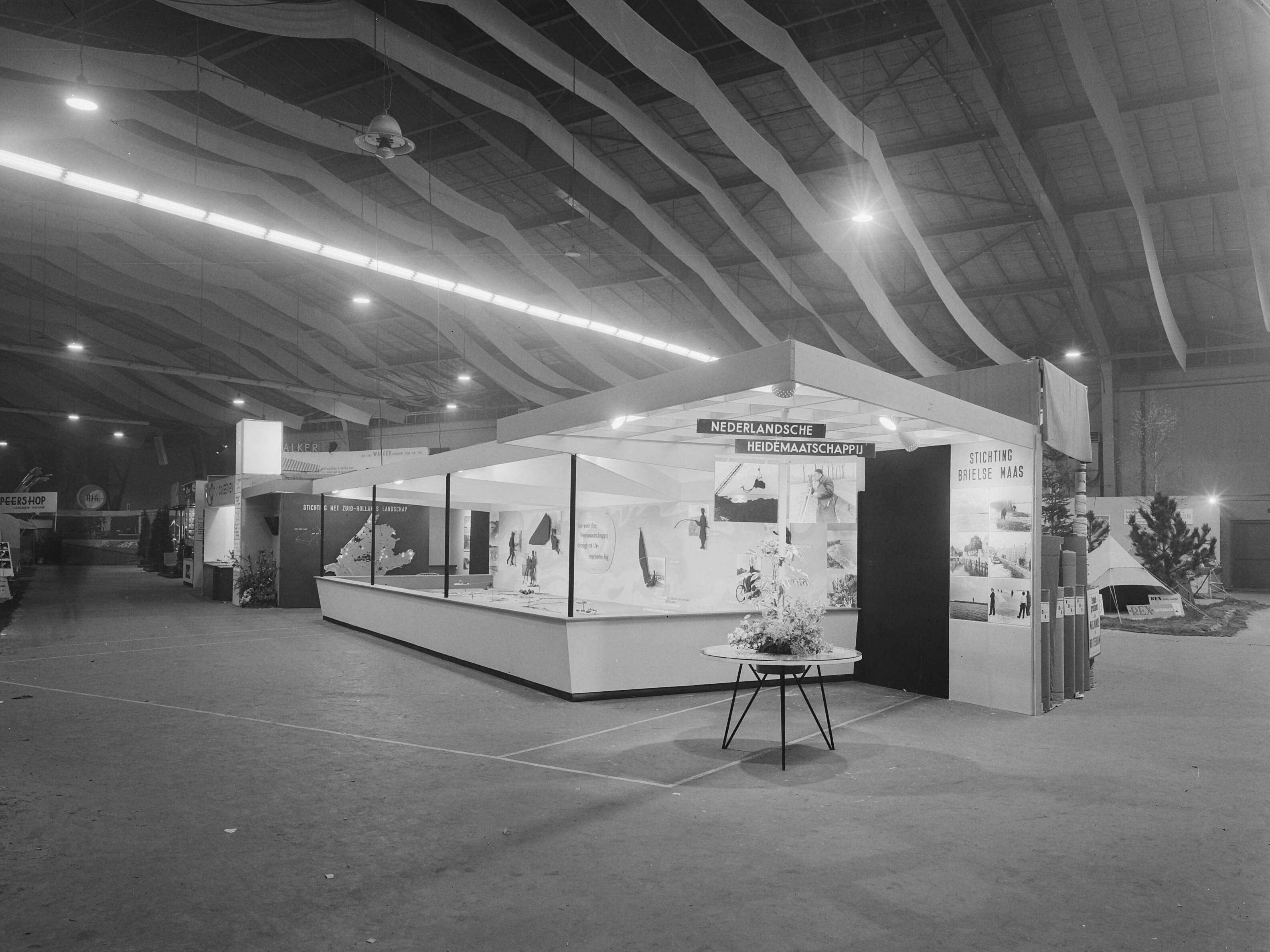 Fotocollectie Nederlandse Heidemaatschappij — Stand op de tentoonstelling "Goed Kamp" te Den Haag — Foto: Wüllschleger, [...] / Heidemij. Licentie: Set B: Rechtenvrij / Publiek Domein. Bron: Nationaal Archief. http://hdl.handle.net/10648/ae7e7abe-d0b4-102d-bcf8-003048976d84