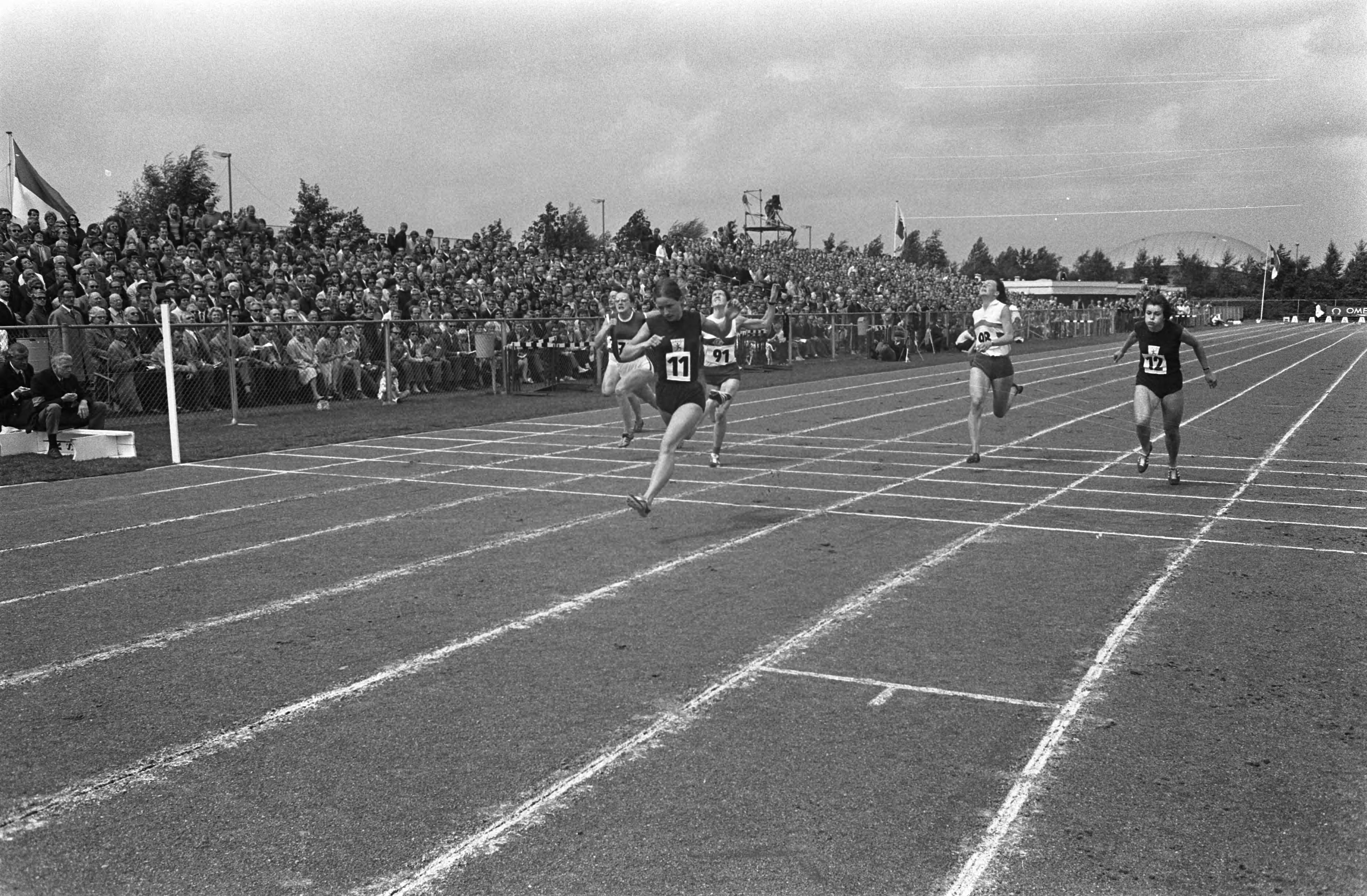 Fotocollectie Anefo — Nationale atletiekkampioenschappen in Haarlem; finish 100 meter dames, winnares Wilma van den Berg (nr. 11) — Foto: Koch, Eric / Anefo. Licentie: Set B: Rechtenvrij / Publiek Domein. Bron: Nationaal Archief. http://hdl.handle.net/10648/ab9e09fe-d0b4-102d-bcf8-003048976d84