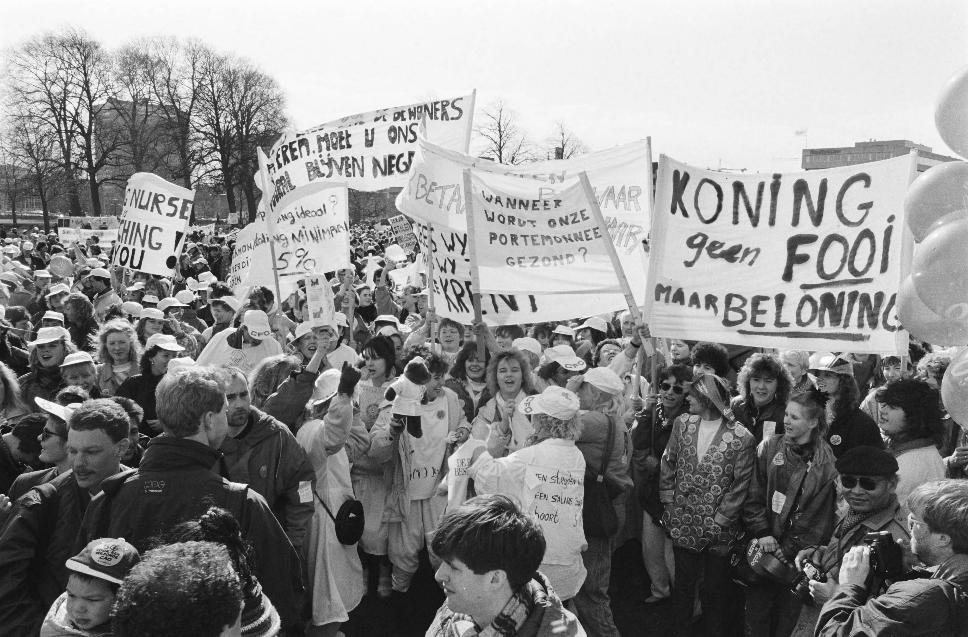 Actiedag van verpleegkundigen voor hoger loon georganiseerd door VVIO (verplegenden en verzorgenden in opstand) — Demonstranten met spandoeken op het Malieveld in Den Haag — Foto: Croes, Rob C. / Anefo. Licentie: Set B: Rechtenvrij / Publiek Domein. Bron: Nationaal Archief. http://hdl.handle.net/10648/ad7191b0-d0b4-102d-bcf8-003048976d84
