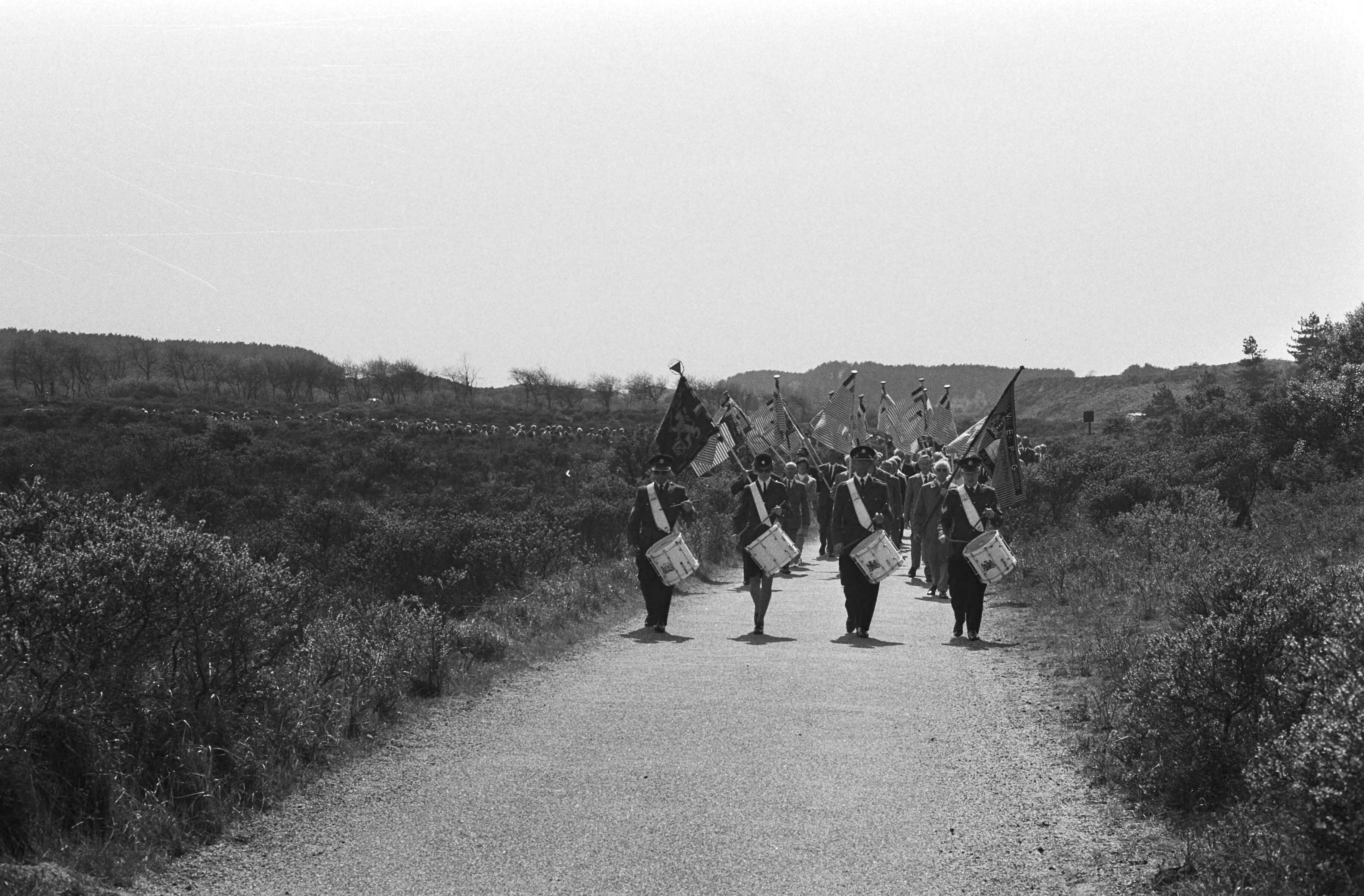 Jaarlijkse herdenking van 1940-1945 op de erebegraafplaats te Overveen — Stille tocht naar de erebegraafplaats voorafgegaan door de Koninklijke Militaire Kapel — Foto: Fotograaf Onbekend / Anefo. Licentie: Set B: Rechtenvrij / Publiek Domein. Bron: Nationaal Archief. http://hdl.handle.net/10648/abbe9dae-d0b4-102d-bcf8-003048976d84