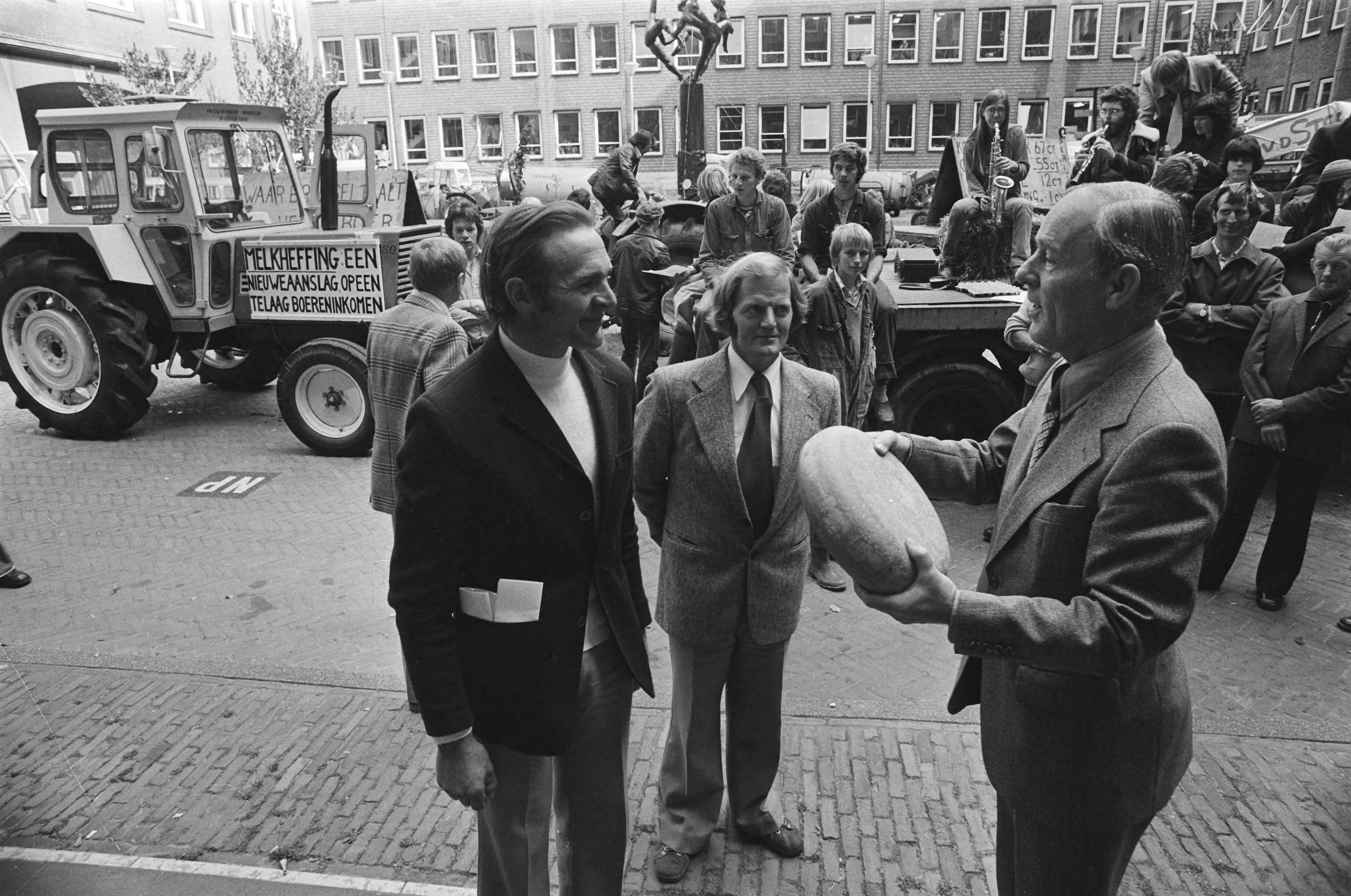 Fotocollectie Anefo — Boeren demonstreren tegen melkheffing op Binnenhof in Den Haag ; aanbieding kaas — Foto: Suyk, Koen / Anefo. Licentie: Set B: Rechtenvrij / Publiek Domein. Bron: Nationaal Archief. http://hdl.handle.net/10648/aca2ae18-d0b4-102d-bcf8-003048976d84