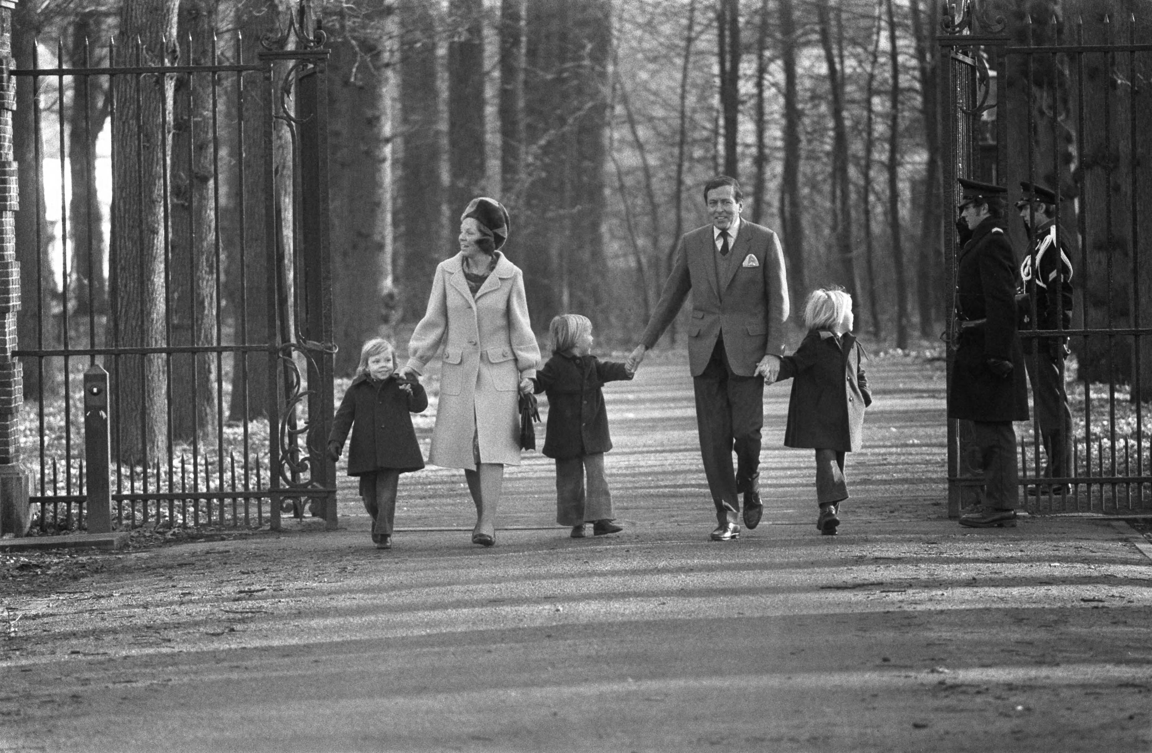 Prinses Beatrix opent het dorpshuis Lage Vuursche — Prinses Beatrix en Prins Claus lopen hand in hand met (van links naar rechts)Willem-Alexander en Constantijn over de toegangslaan, op de voorgrond twee leden van de marechaussee — Foto: Fotograaf Onbekend / Anefo. Licentie: Set B: Rechtenvrij / Publiek Domein. Bron: Nationaal Archief. http://hdl.handle.net/10648/ac427c8c-d0b4-102d-bcf8-003048976d84