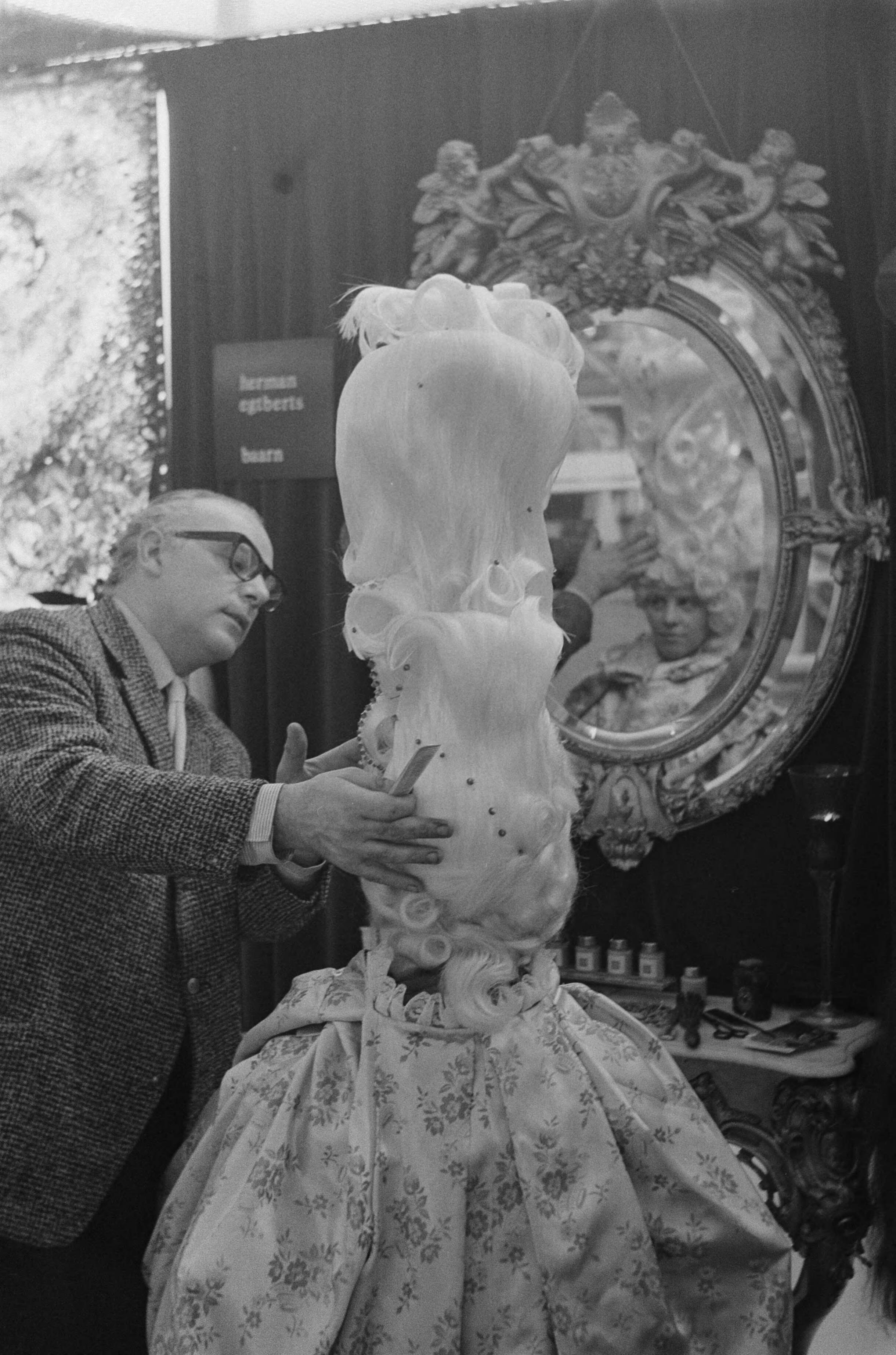 Fotocollectie Anefo — Expobeurs in Hilversum. Kapper Herman Egbert met pruiken van anderhalve meter — Foto: Koch, Eric / Anefo. Licentie: Set B: Rechtenvrij / Publiek Domein. Bron: Nationaal Archief. http://hdl.handle.net/10648/aa2ddec8-d0b4-102d-bcf8-003048976d84