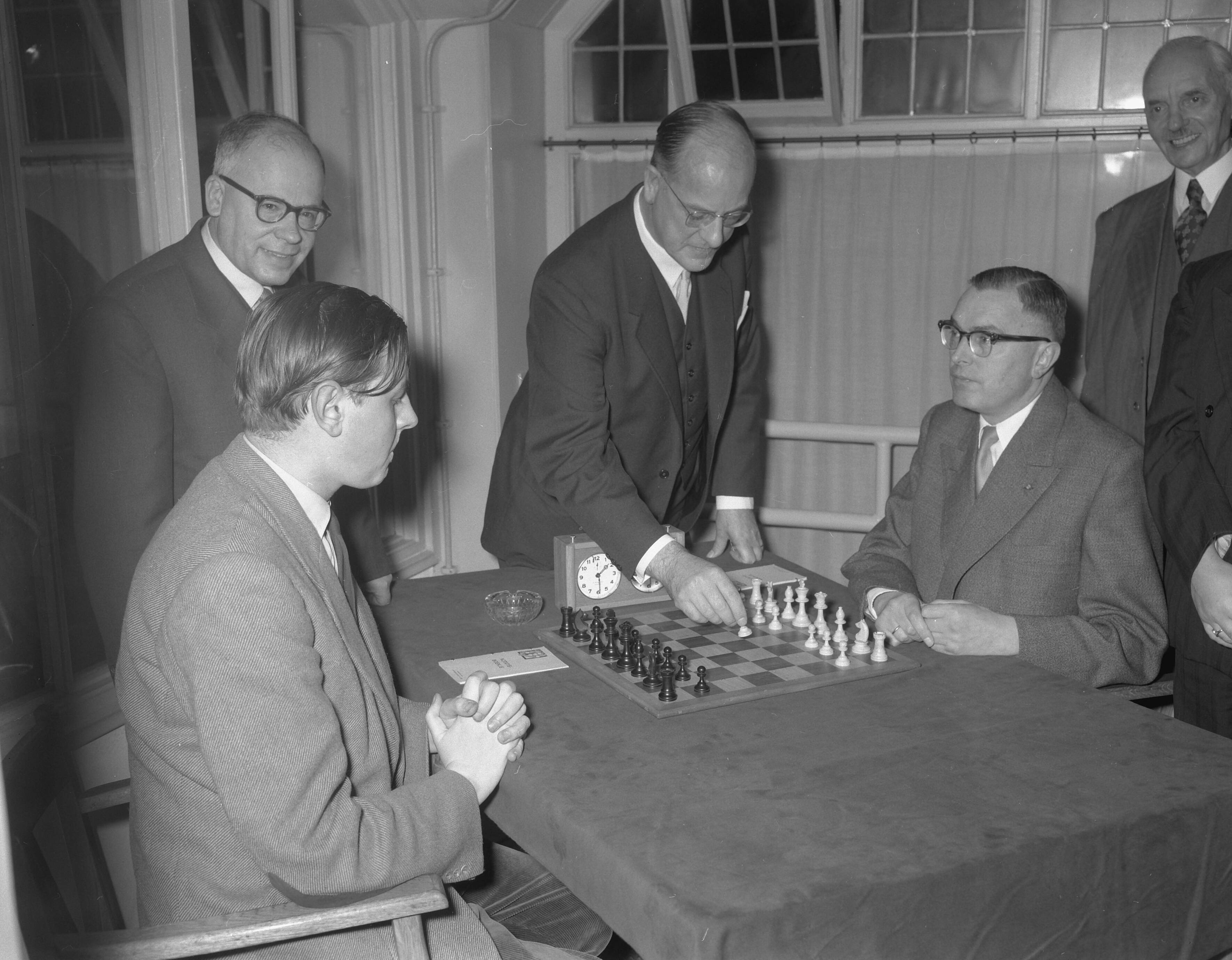 Fotocollectie Anefo — Tweekamp om het Nederlandse kampioenschap schaken tussen Max Euwe en Jan Hein Donner (links). Burgemeester mr. F.J.A. Schokking van Den Haag doet eerste zet. Links staand de directeur van De Telegraaf, C.M. Drobbe — Foto: Noske, J.D. / Anefo. Licentie: Set B: Rechtenvrij / Publiek Domein. Bron: Nationaal Archief. http://hdl.handle.net/10648/a940e488-d0b4-102d-bcf8-003048976d84
