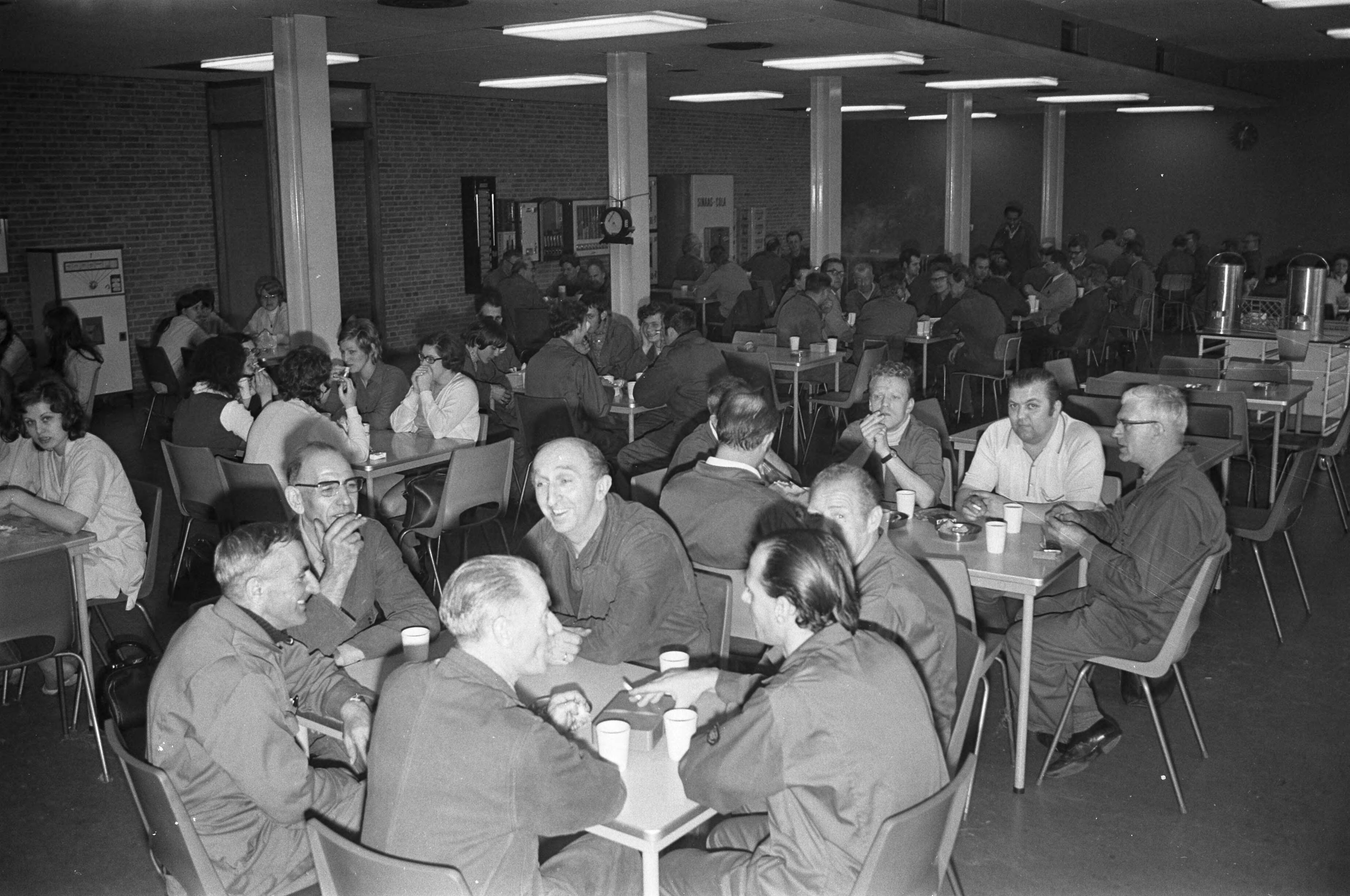 Fotocollectie Anefo — ENKA (onderdeel van AKZO) te Breda stopt produktie; arbeiders in de kantine — Foto: Peters, Hans / Anefo. Licentie: Set B: Rechtenvrij / Publiek Domein. Bron: Nationaal Archief. http://hdl.handle.net/10648/abe6584e-d0b4-102d-bcf8-003048976d84