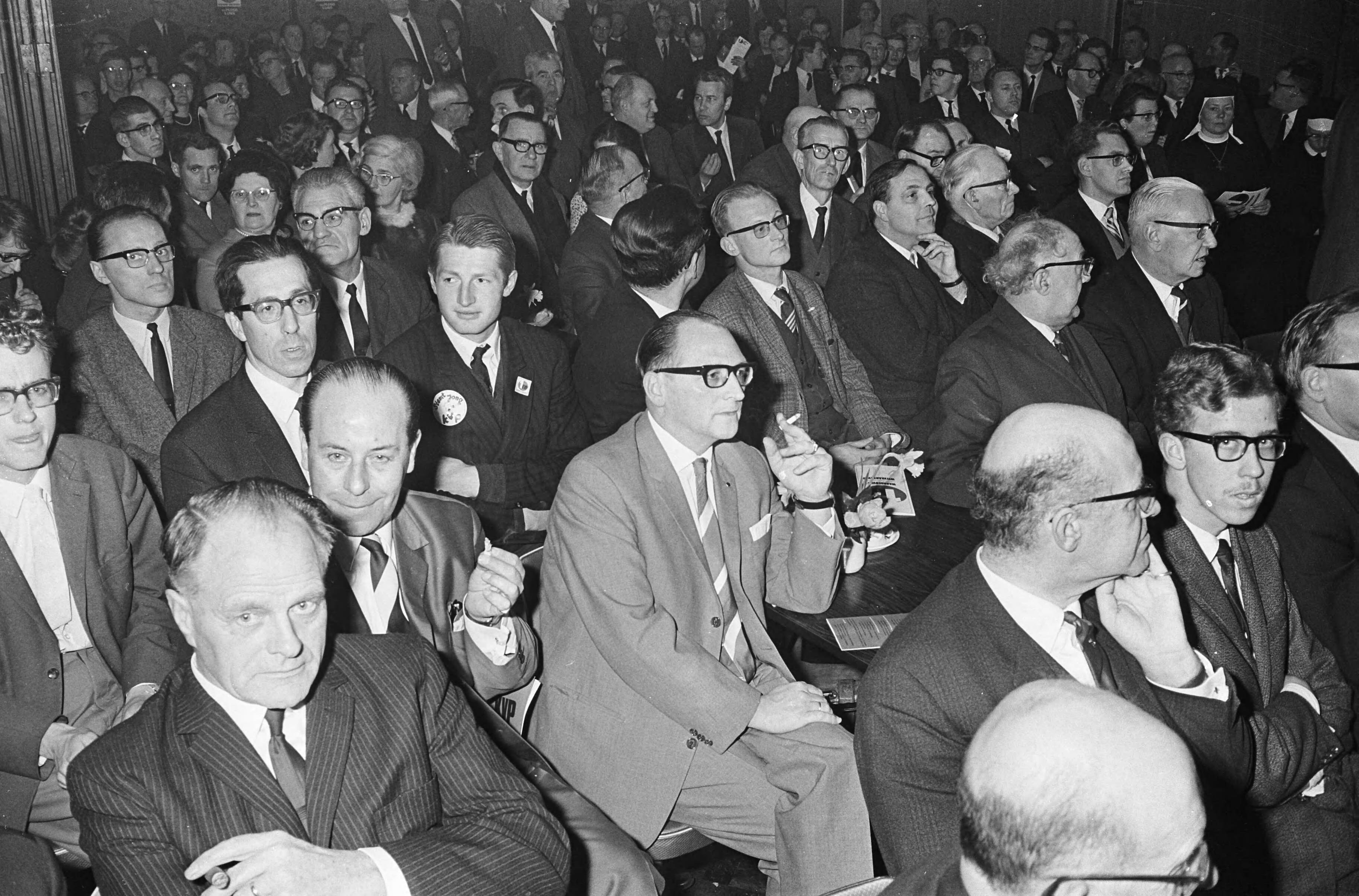 Fotocollectie Anefo — Verkiezingsvergadering KVP te Haarlem, de belangstelling was groot — Foto: Merk, Ben / Anefo. Licentie: Set B: Rechtenvrij / Publiek Domein. Bron: Nationaal Archief. http://hdl.handle.net/10648/ab0ed4fa-d0b4-102d-bcf8-003048976d84