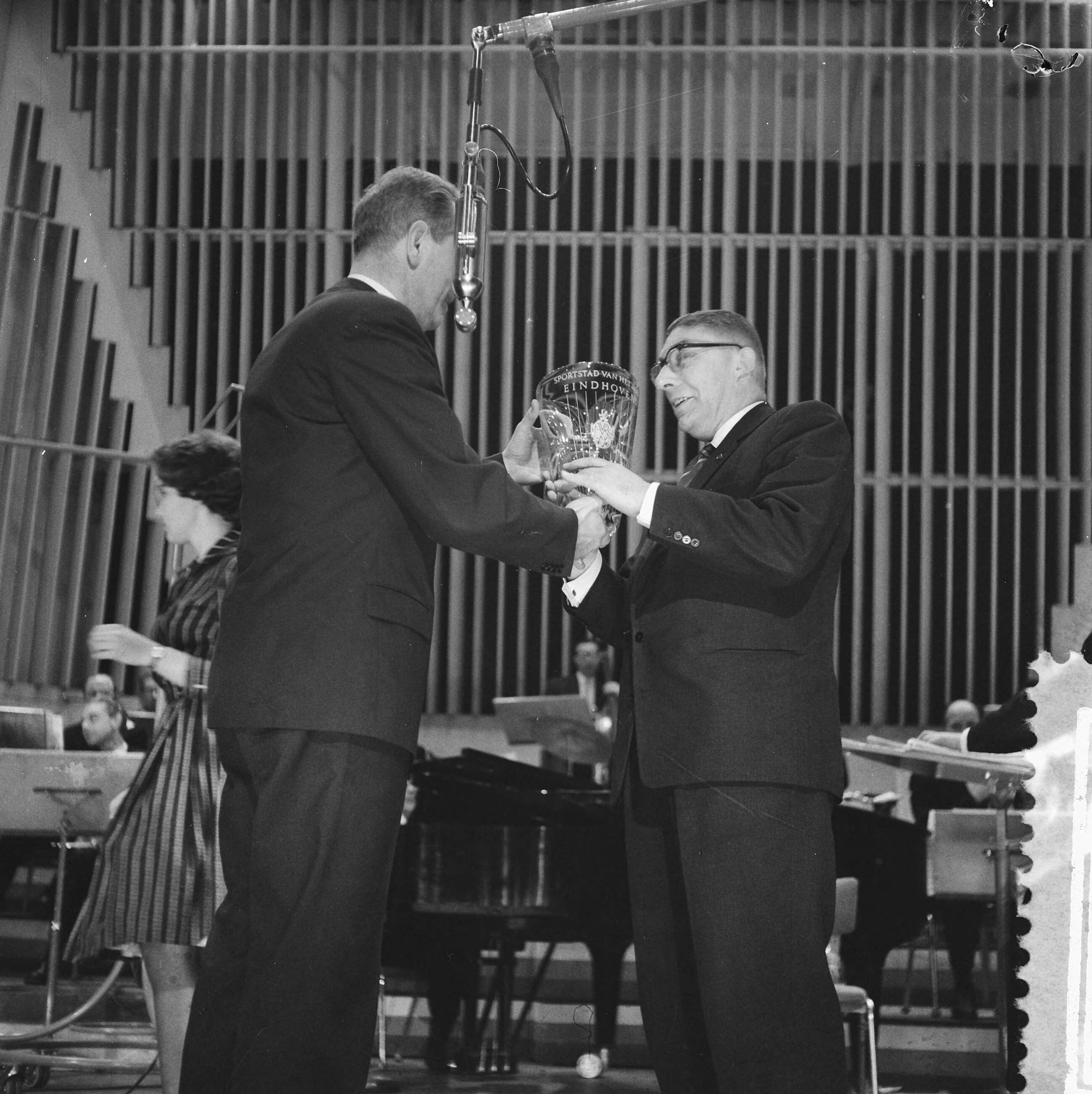 Fotocollectie Anefo — Verkiezing Sportman, Sportvrouw en Sportstad van het jaar. Directeur van de AVRO, D. Repko, overhandigt de loco-burgemeester van Eindhoven F.J.W. Gijzels de bokaal — Foto: Lindeboom, Henk / Anefo. Licentie: Set B: Rechtenvrij / Publiek Domein. Bron: Nationaal Archief. http://hdl.handle.net/10648/a9a4dc04-d0b4-102d-bcf8-003048976d84