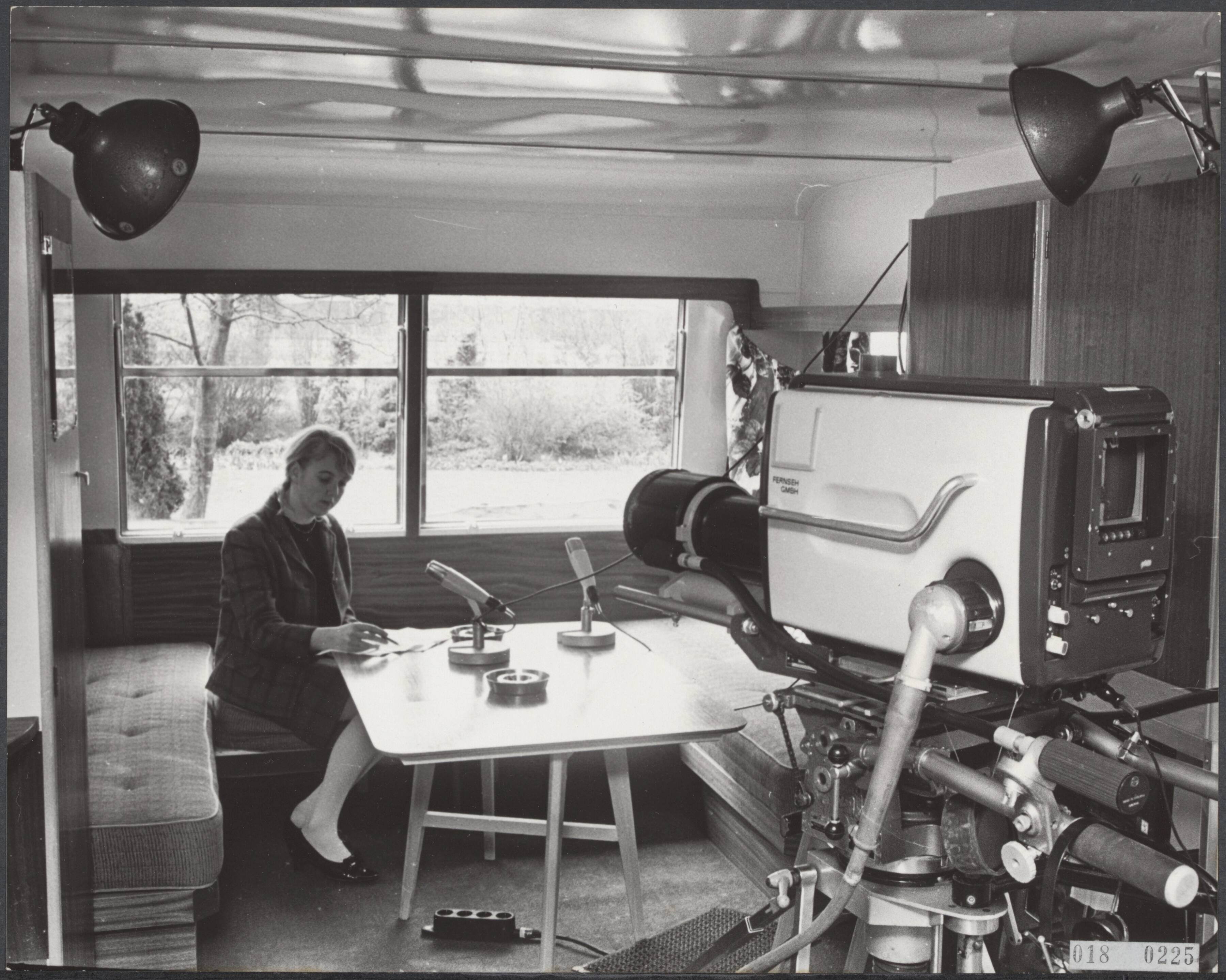 Fotocollectie Elsevier Binnenland — De Nederlandse televisie heeft in Lage Vuursche een caravan klaar staan, ingericht als noodstudio, waar, zoals men hoopt, prins Claus straks officiëel voor de camera de geboorte zal aankondigne. Laura Smits van de NTS, zorgt ervoor dat de studio elke dag schoon is. — Foto: Koch, Eric / Anefo. Licentie: Set B: Rechtenvrij / Publiek Domein. Bron: Nationaal Archief. http://hdl.handle.net/10648/adc19d2c-d0b4-102d-bcf8-003048976d84