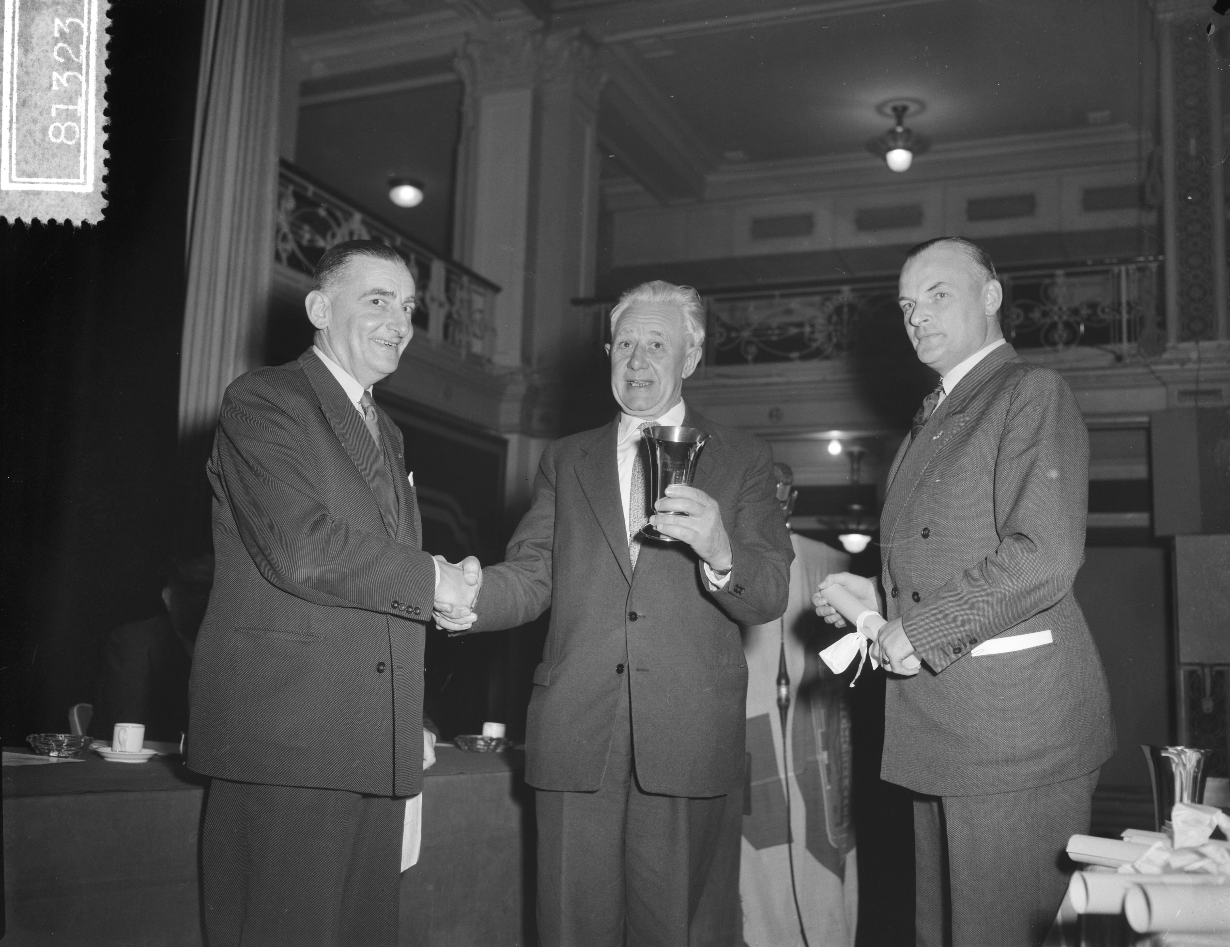 Fotocollectie Anefo — Opening Wegverkeersdag van het KNAC in het Kurhaus te Scheveningen. De voorzitter van het juridisch-economisch-verkeerstechnisch college, mr. D. J. van Gilsen, procureur-generaal bij het Haags Gerechtshof, overhandigde de definitiefe wisselbeker en oorkonde voor veiligste stad aan Den Haag — Foto: Bilsen, Joop van / Anefo. Licentie: Set B: Rechtenvrij / Publiek Domein. Bron: Nationaal Archief. http://hdl.handle.net/10648/a9526dd4-d0b4-102d-bcf8-003048976d84