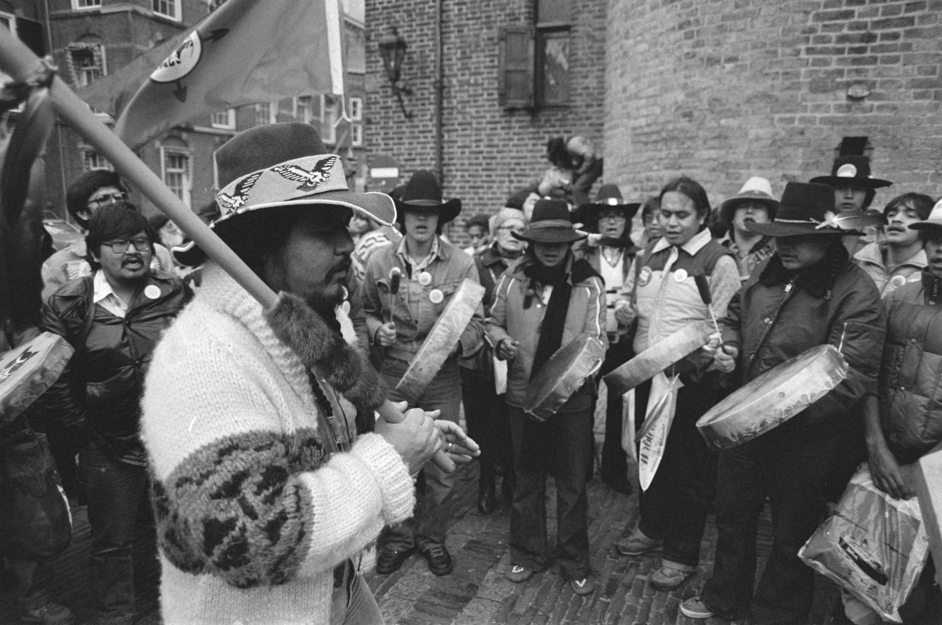 Groep Canadese Indianen demonstreert op het Binnenhof in Den Haag, teneinde aandacht te verkrijgen voor de situatie in hun land — Den Haag|Zuid-Holland|indianen |demonstraties — Foto: Antonisse, Marcel / Anefo. Licentie: Set B: Rechtenvrij / Publiek Domein. Bron: Nationaal Archief. http://hdl.handle.net/10648/ad08919c-d0b4-102d-bcf8-003048976d84