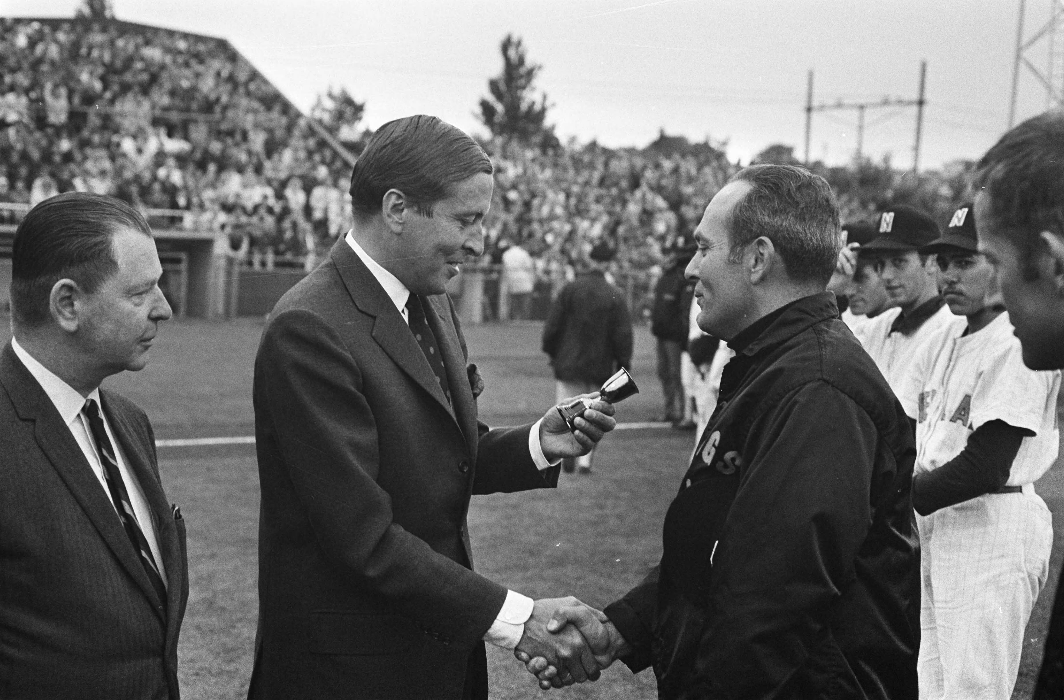 Haarlemse Honkbalweek — Prins Claus bij spelers van de California Stags — Foto: Fotograaf Onbekend / Anefo. Licentie: Set B: Rechtenvrij / Publiek Domein. Bron: Nationaal Archief. http://hdl.handle.net/10648/ab702886-d0b4-102d-bcf8-003048976d84
