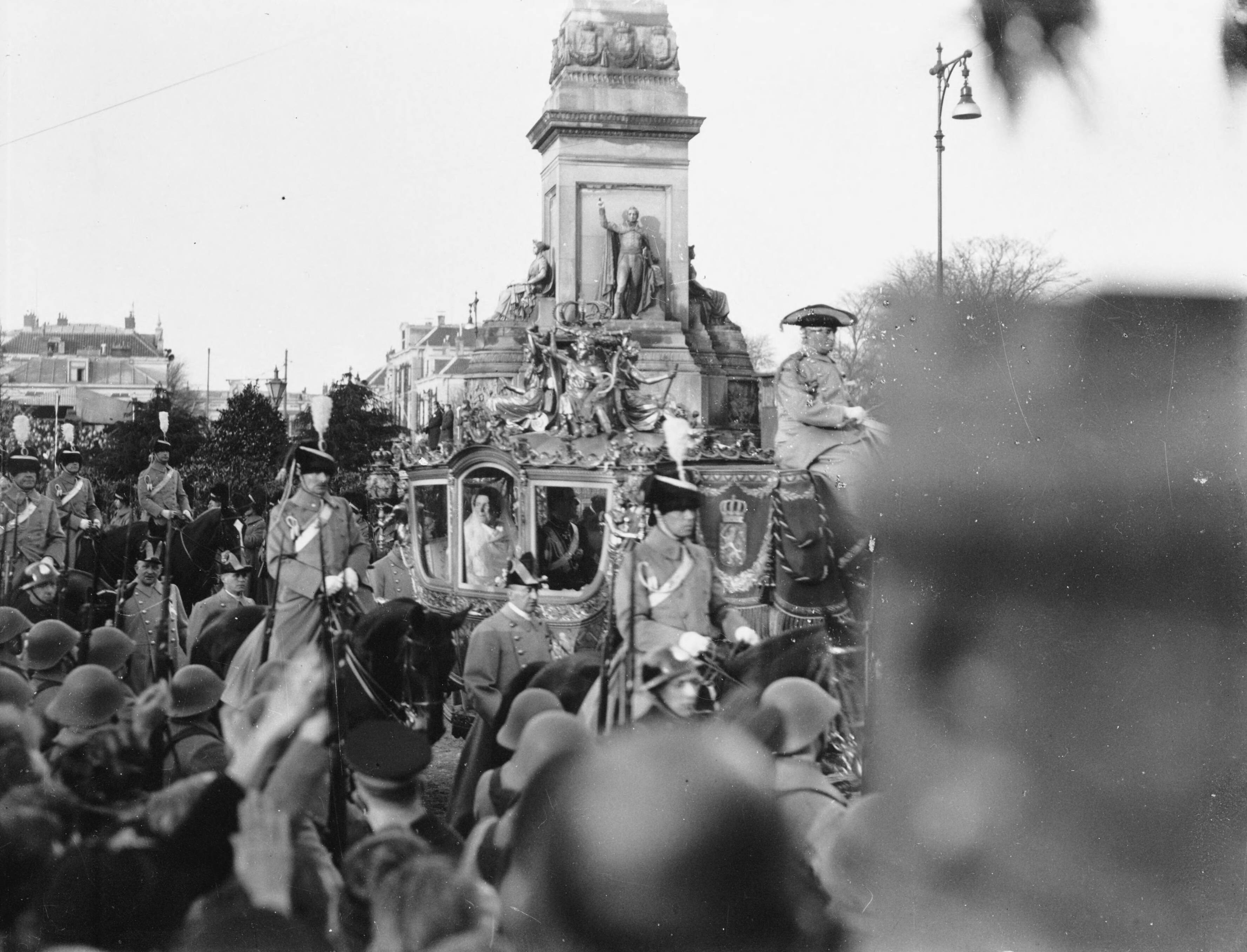Fotocollectie RVD / Koninklijk Huis — Huwelijk prinses Juliana en prins Bernhard. Rijtoer per Gouden Koets in Den Haag, hier op Plein 1813, donderdag 7 januari 1937 — Foto: Rousel (repro) / RVD. Licentie: Set B: Rechtenvrij / Publiek Domein. Bron: Nationaal Archief. http://hdl.handle.net/10648/afb5d828-d0b4-102d-bcf8-003048976d84