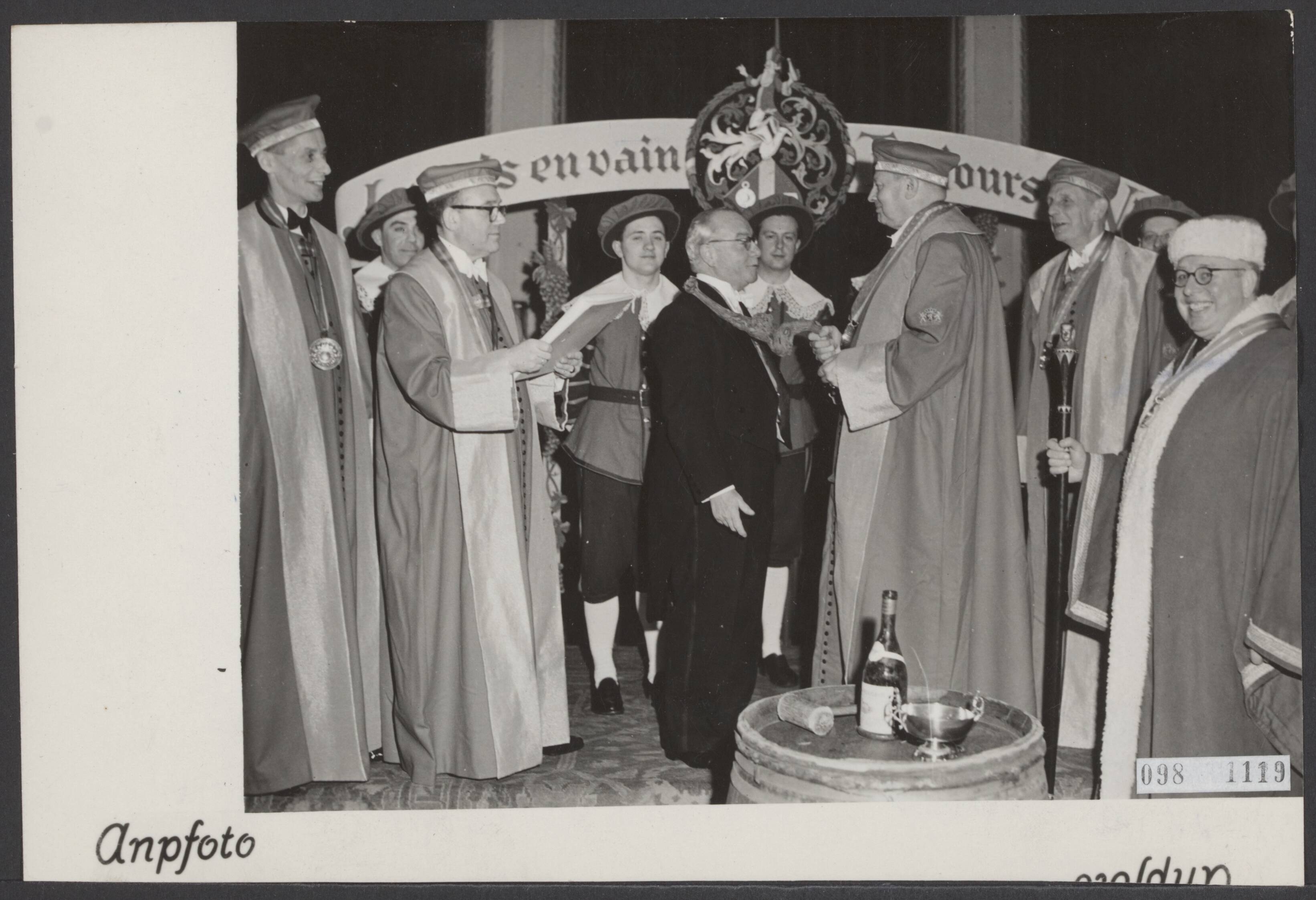 Fotocollectie Elsevier Binnenland — Inauguratie van nieuwe leden van de Confrerie des Chevaliers du Tastevin in kasteel Oud-Wassenaar. De Delegué general van de Confrerie in Nederland, de heer H.W.A. van Oordt, slaat de consul-generaal van Frankrijk, de heer P. Béchet, met een wijnrank tot ridder — Foto: ANP / RVD of rechtenvrij. Licentie: Set B: Rechtenvrij / Publiek Domein. Bron: Nationaal Archief. http://hdl.handle.net/10648/ae2dfa12-d0b4-102d-bcf8-003048976d84