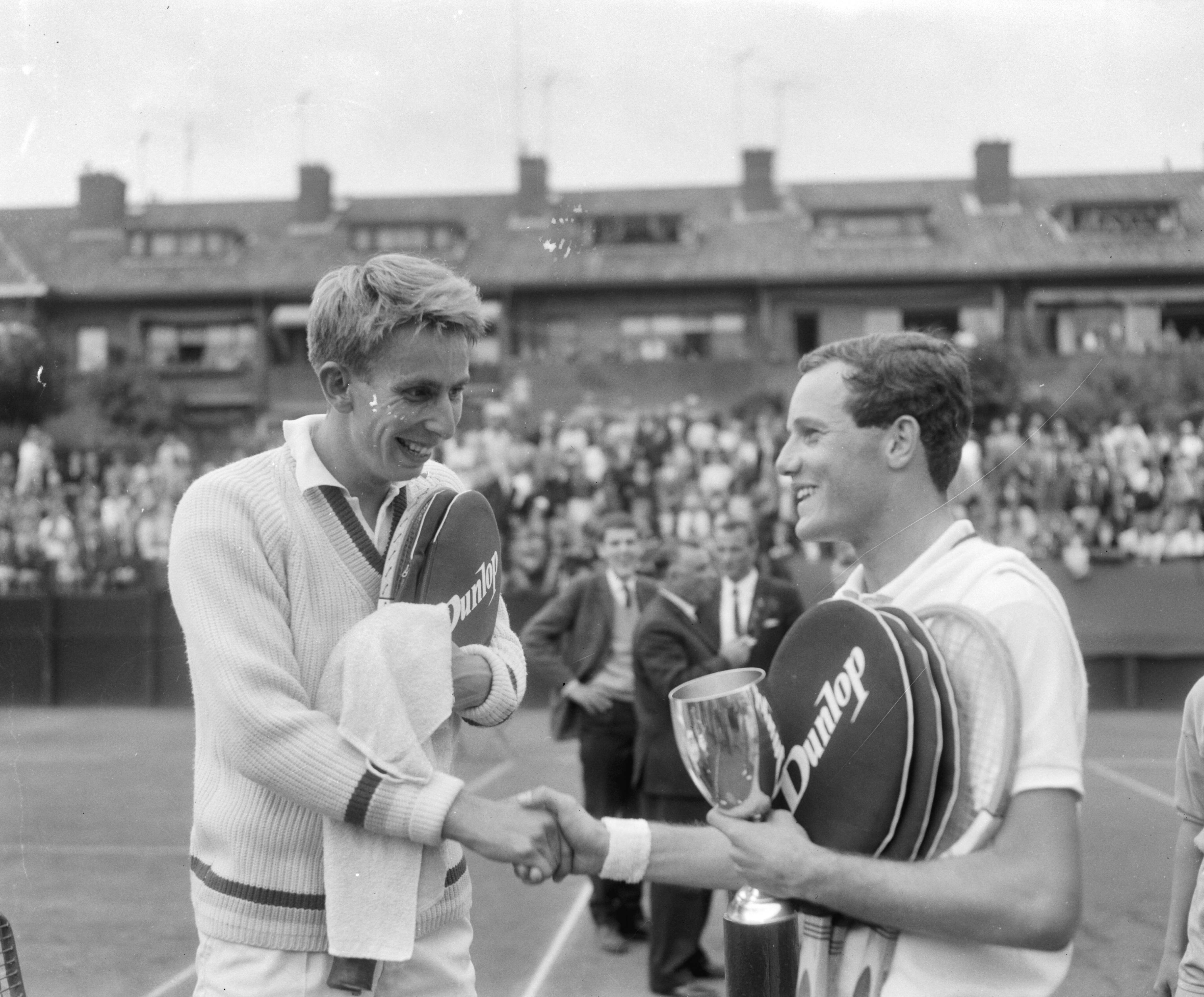 Fotocollectie Anefo — Nederlandse tenniskampioenschappen op de METS-banen te Scheveningen, finale herenenkel, Evert Schneider (links) feliciteert winnaar Tom Okker — Foto: Bilsen, Joop van / Anefo. Licentie: Set B: Rechtenvrij / Publiek Domein. Bron: Nationaal Archief. http://hdl.handle.net/10648/aabb3980-d0b4-102d-bcf8-003048976d84