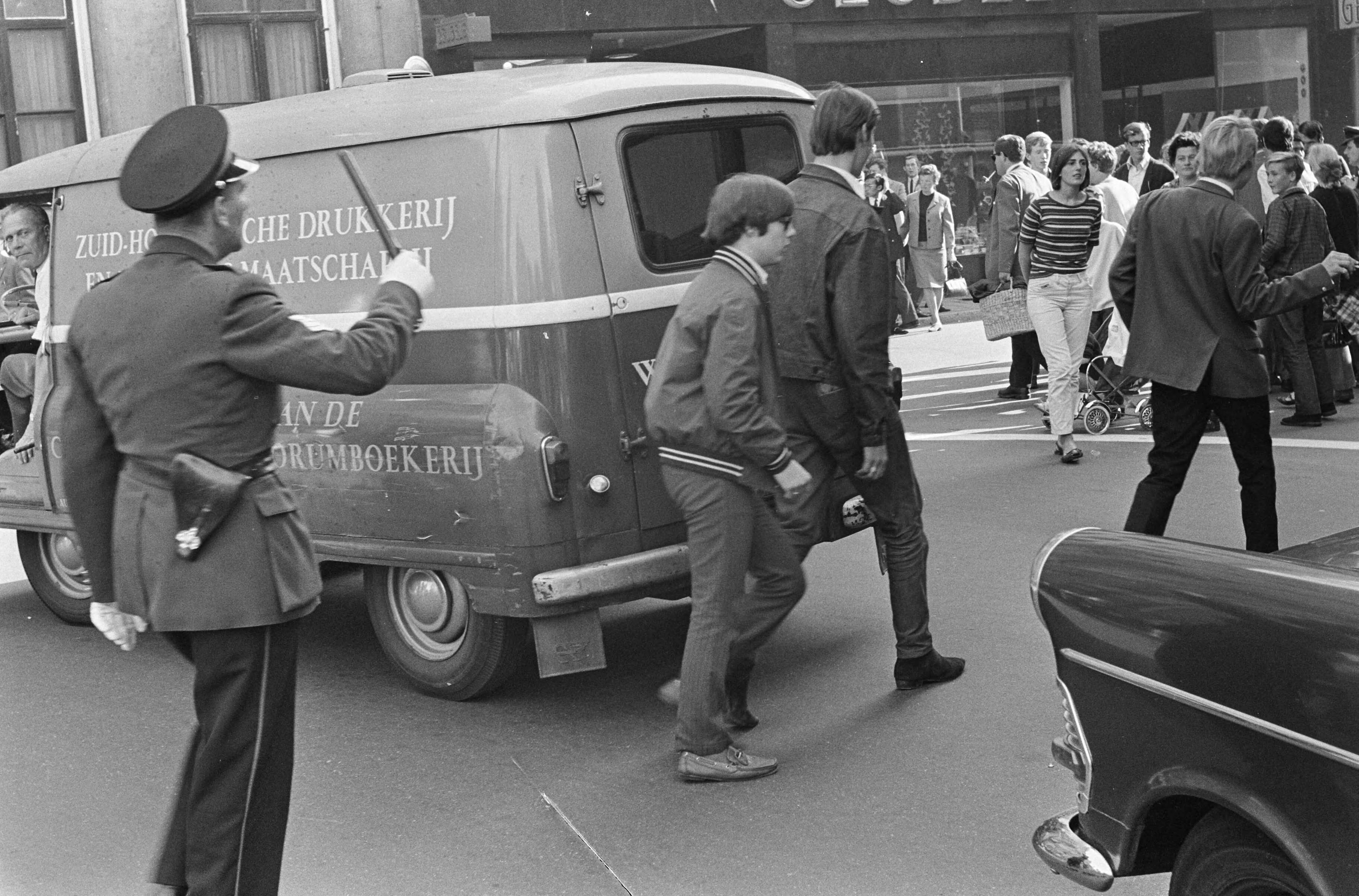 Protesterende Amsterdamse Provo's tijdens Prinsjesdag 1966 in Den Haag — Het publiek wordt door de politie gemaand om door te lopen — Foto: Fotograaf Onbekend / Anefo. Licentie: Set B: Rechtenvrij / Publiek Domein. Bron: Nationaal Archief. http://hdl.handle.net/10648/aafd3dda-d0b4-102d-bcf8-003048976d84