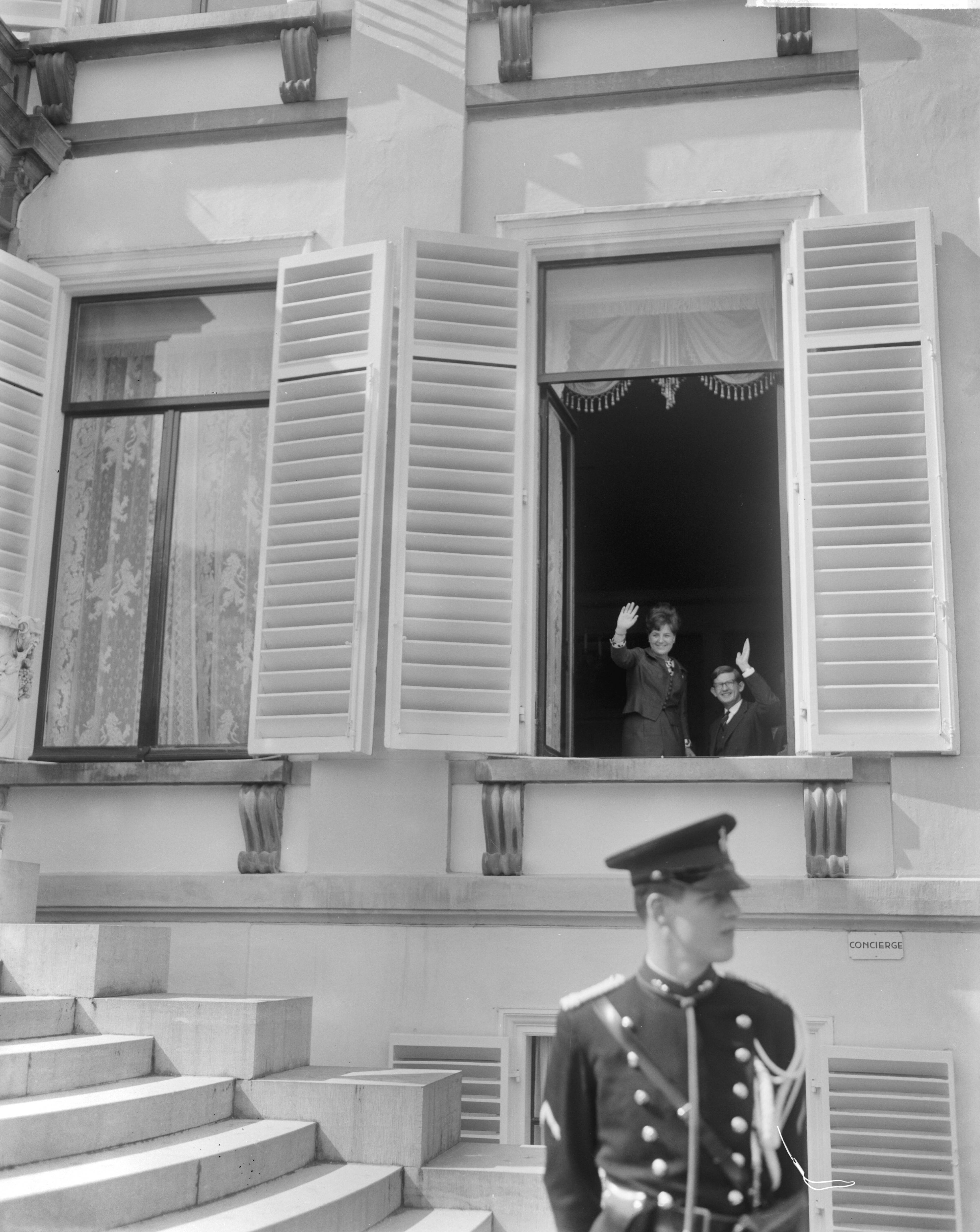 Koninginnedag 1965 — Prinses Margriet en Pieter van Vollenhoven zwaaien vanuit een geopend raam — Foto: Bilsen, Joop van / Anefo. Licentie: Set B: Rechtenvrij / Publiek Domein. Bron: Nationaal Archief. http://hdl.handle.net/10648/aaa43398-d0b4-102d-bcf8-003048976d84