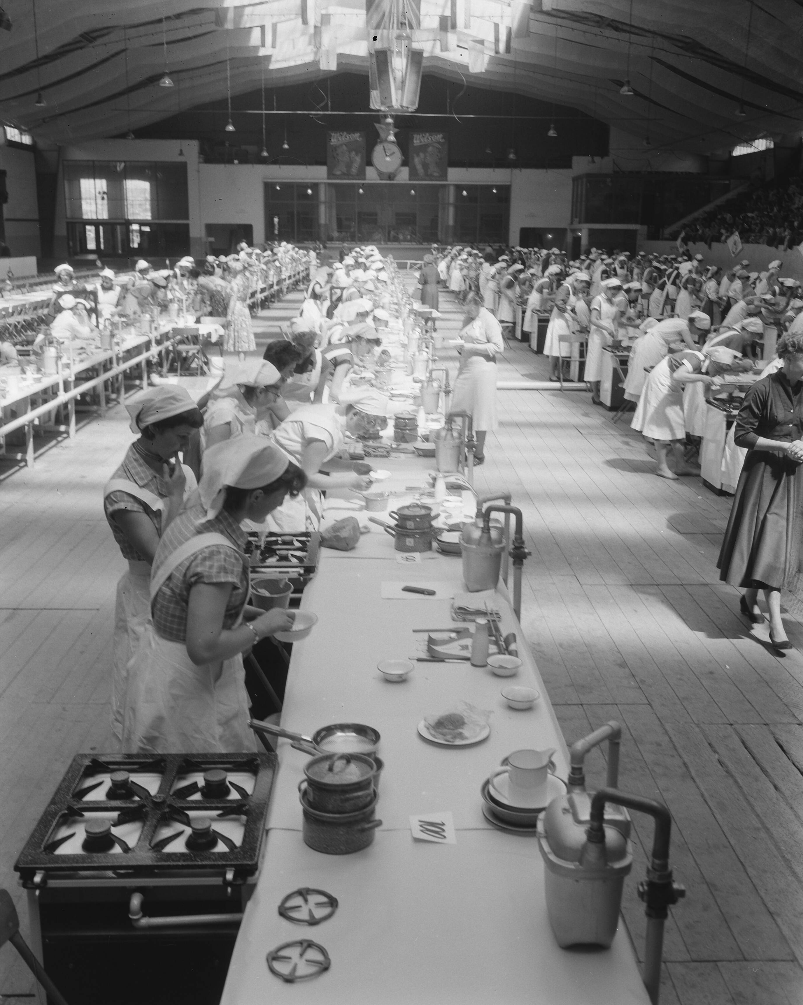 Fotocollectie Anefo — Nationale kookwedstrijd in de Houtrusthallen in Den Haag 250 Leerlingen West-Nederlandse huishoudscholen — Foto: Pot, Harry / Anefo. Licentie: Set B: Rechtenvrij / Publiek Domein. Bron: Nationaal Archief. http://hdl.handle.net/10648/a95fb0ac-d0b4-102d-bcf8-003048976d84