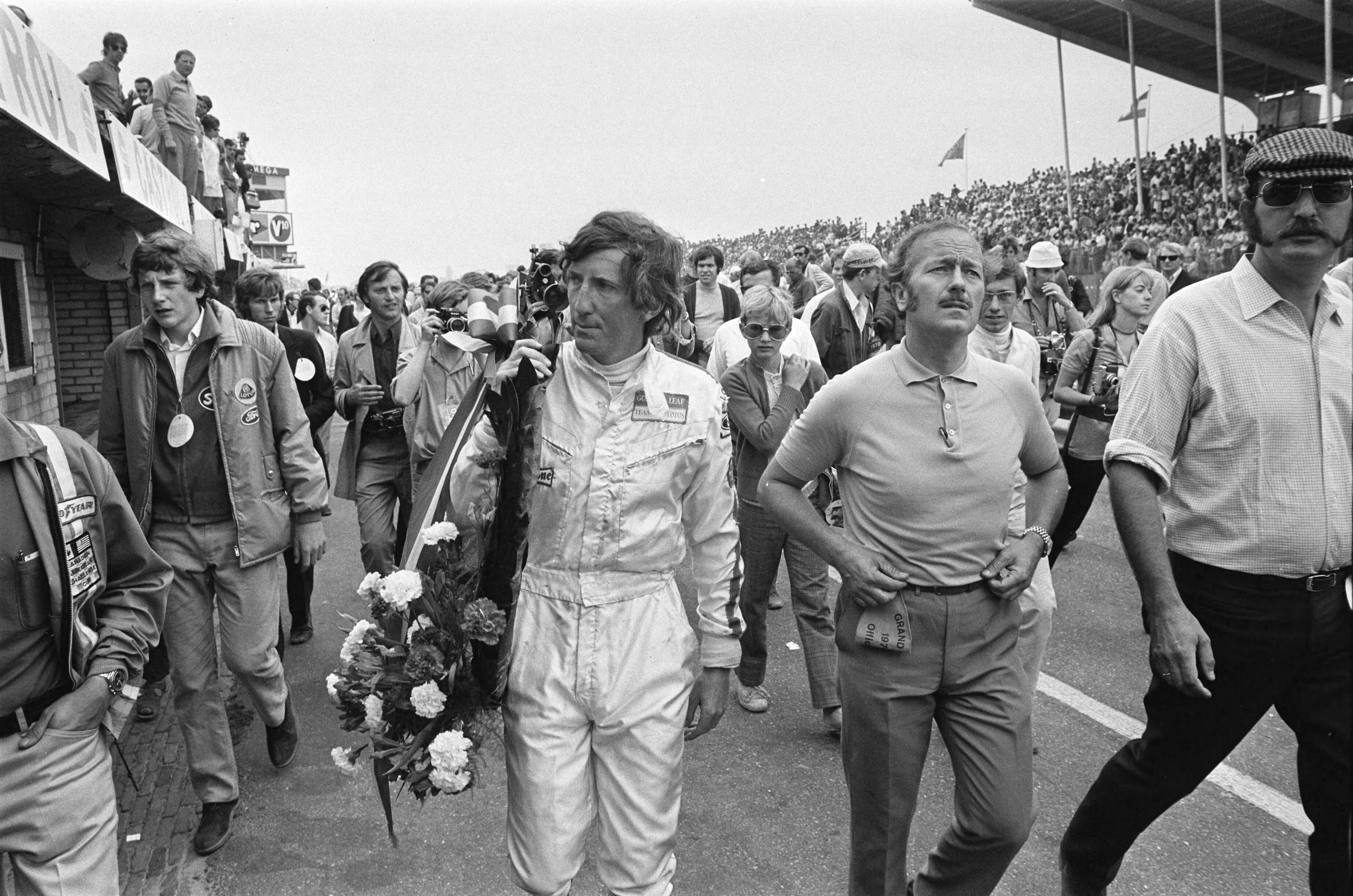 Grand Prix Zandvoort 1970 — Grand Prix 1970 van Nederland voor Formule I wagens , Zandvoort; Jochem Rindt (links) met krans, rechts Lotus constructeur Colin Chapman — Foto: Evers, Joost / Anefo. Licentie: Set B: Rechtenvrij / Publiek Domein. Bron: Nationaal Archief. http://hdl.handle.net/10648/ab9a3d92-d0b4-102d-bcf8-003048976d84