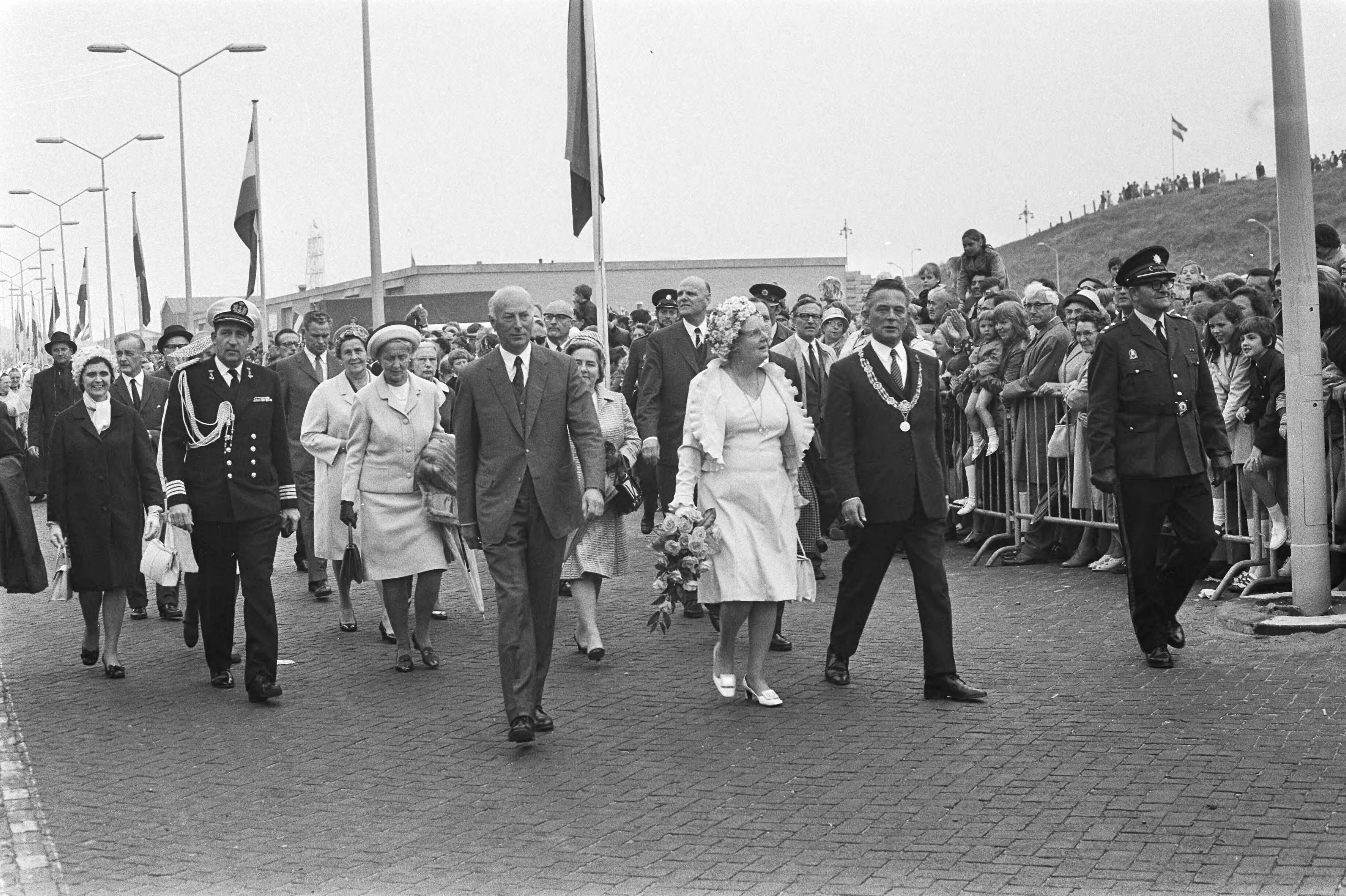 Koningin Juliana opent Havenmond, Scheveningen — Koningin Juliana (m), minister Bakker (l) en burgemeester Marijnen (r) wandelen door de haven — Foto: Fotograaf Onbekend / Anefo. Licentie: Set B: Rechtenvrij / Publiek Domein. Bron: Nationaal Archief. http://hdl.handle.net/10648/abc049c4-d0b4-102d-bcf8-003048976d84