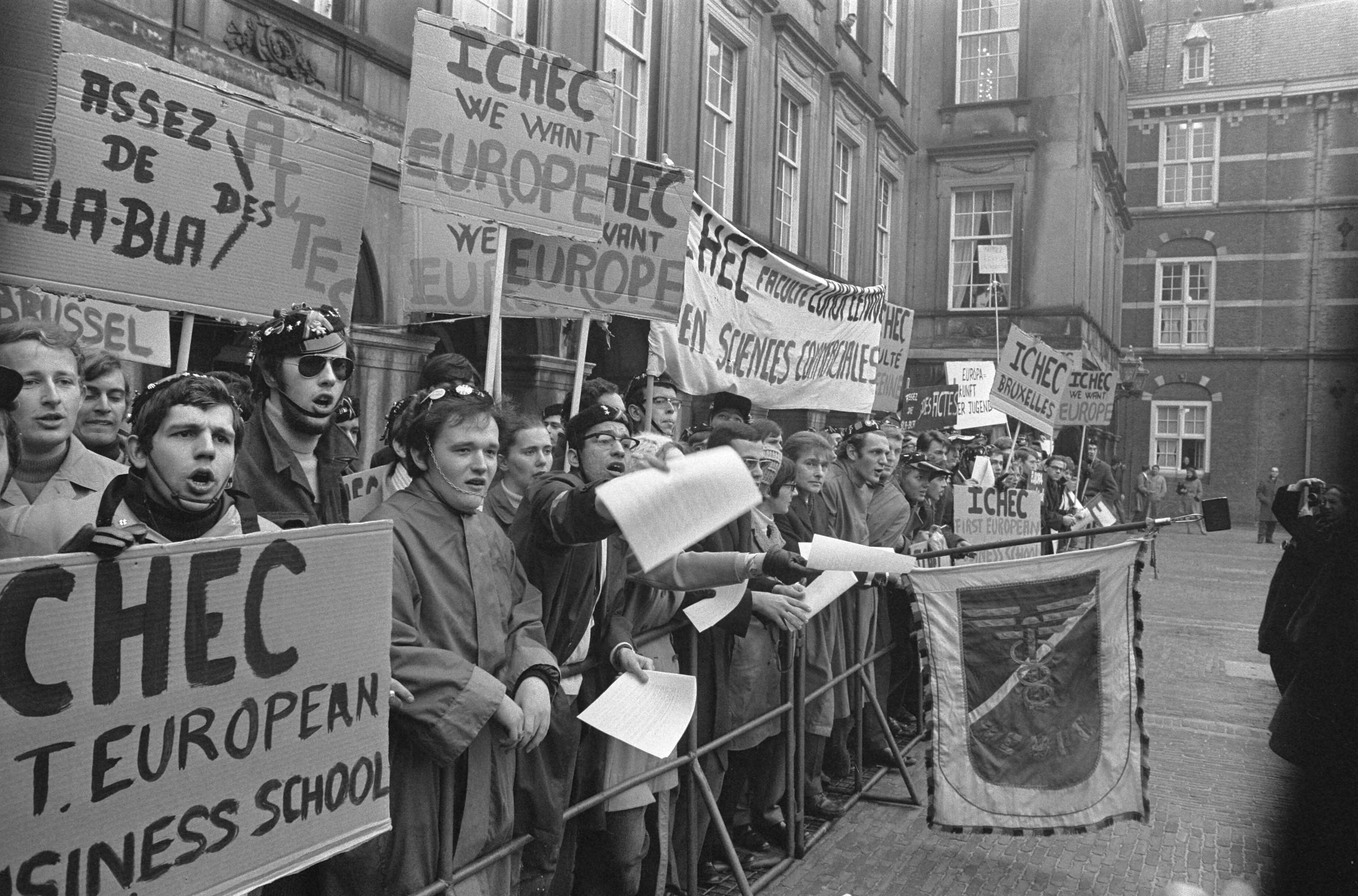 Fotocollectie Anefo — Demonstraties bij het Binnenhof Den Haag tijdens EEG- conferentie. Demonstranten met borden, achter dranghekken — Foto: Verhoeff, Bert / Anefo. Licentie: Set B: Rechtenvrij / Publiek Domein. Bron: Nationaal Archief. http://hdl.handle.net/10648/ab842480-d0b4-102d-bcf8-003048976d84