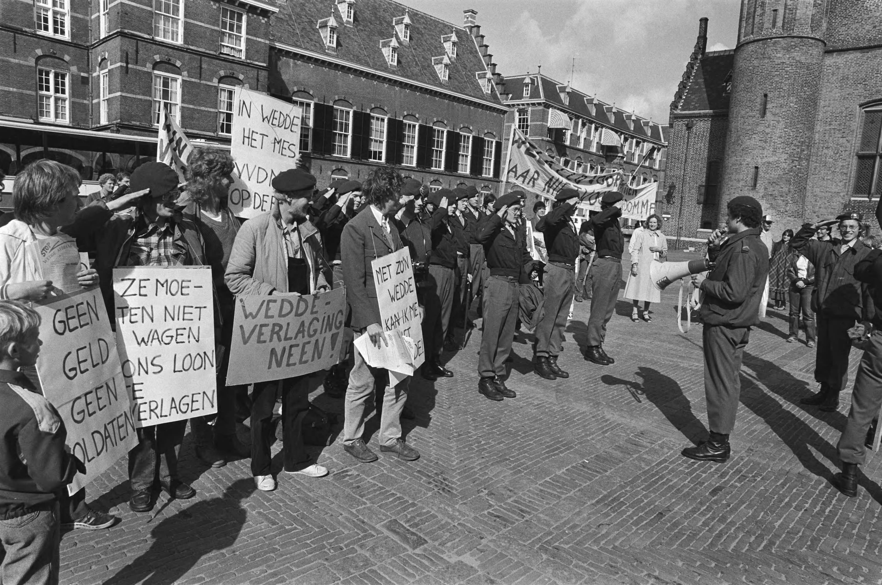 Demonstratie van de Vereniging van Dienstplichtige Militairen tegen weddeverlaging op het Binnenhof in Den Haag — Demonstrerende militairen op het Binnenhof — Foto: Antonisse, Marcel / Anefo. Licentie: Set B: Rechtenvrij / Publiek Domein. Bron: Nationaal Archief. http://hdl.handle.net/10648/ace81c82-d0b4-102d-bcf8-003048976d84