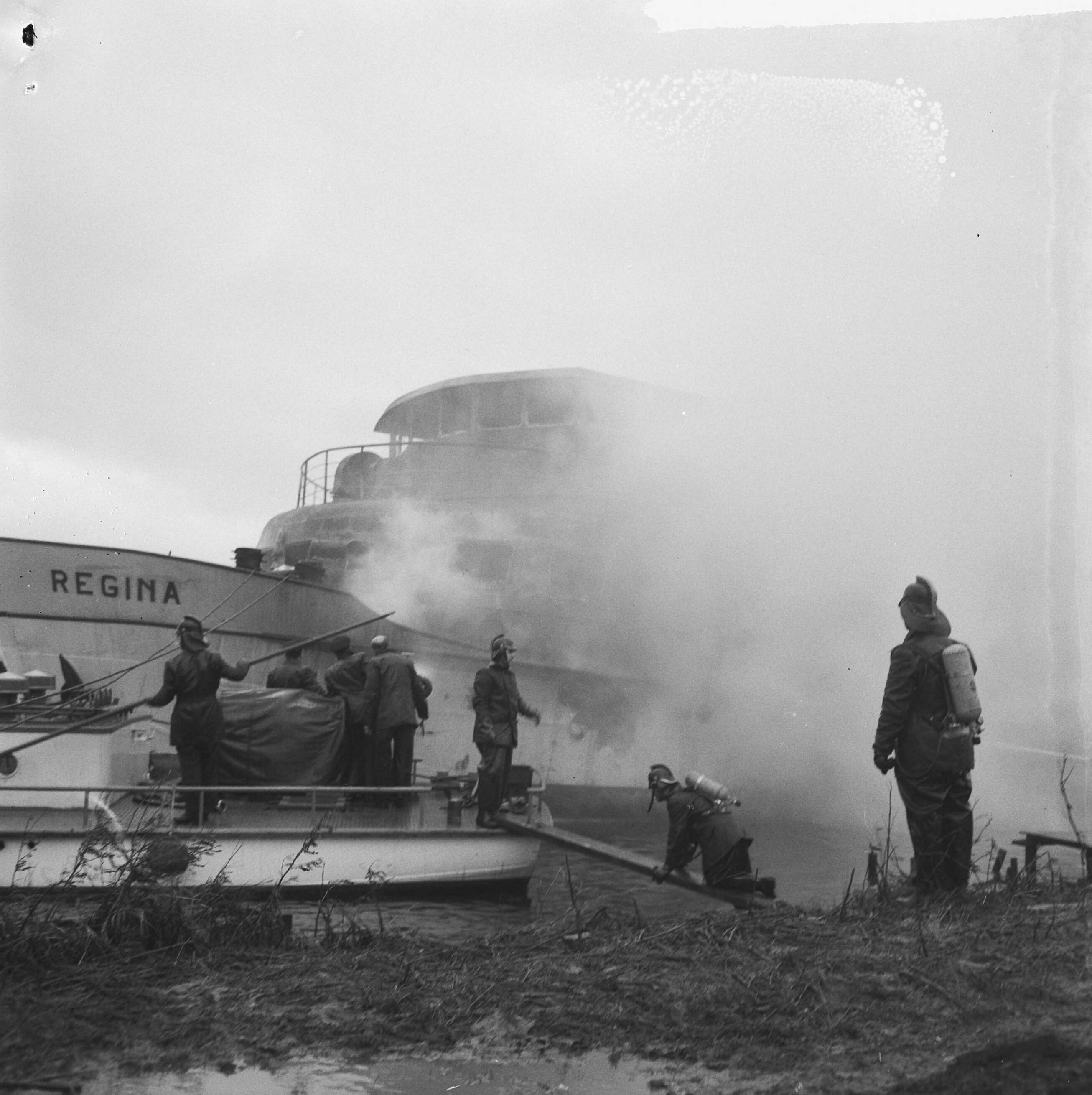 Fotocollectie Anefo — Brandweer tijdens het blussen van het passagierschip Regina bij de Zaanlandse te Zaandam, vanaf een scheepje — Foto: Evers, Joost / Anefo. Licentie: Set B: Rechtenvrij / Publiek Domein. Bron: Nationaal Archief. http://hdl.handle.net/10648/aad0225a-d0b4-102d-bcf8-003048976d84