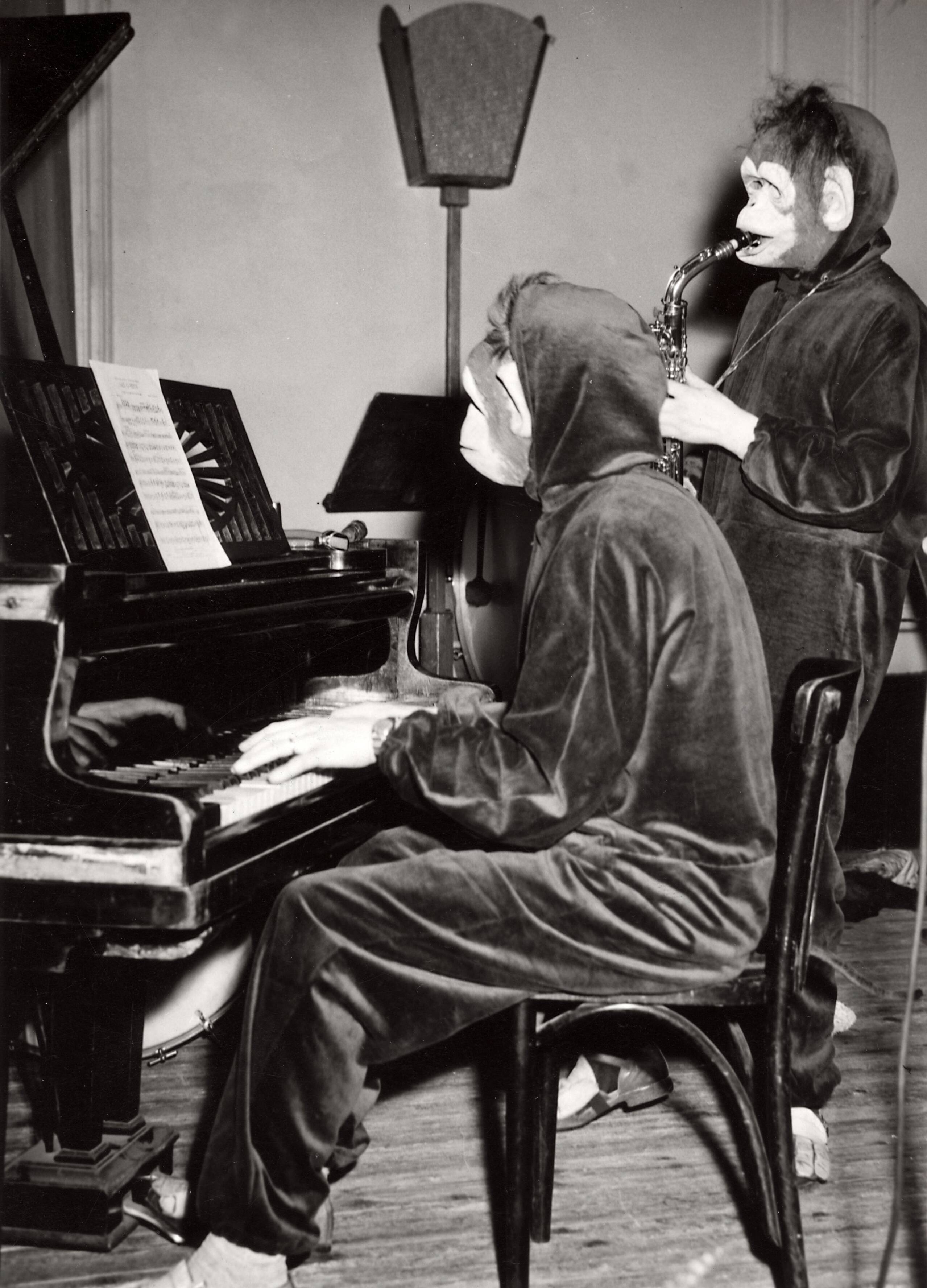 Collectie nader te bepalen — [Harmonie "Amphion" van Drukkerij N.V. Spaarnestad] [twee muzikanten, een pianist en een saxofonist, verkleed als apen, tijdens een optreden] — Foto: Fotograaf Onbekend / Fotobureau onbekend / Spaarnestad Photo (05887). Licentie: Set B: Rechtenvrij / Publiek Domein. Bron: Nationaal Archief. http://hdl.handle.net/10648/35429da6-3c4f-a382-e063-6df0900a6686