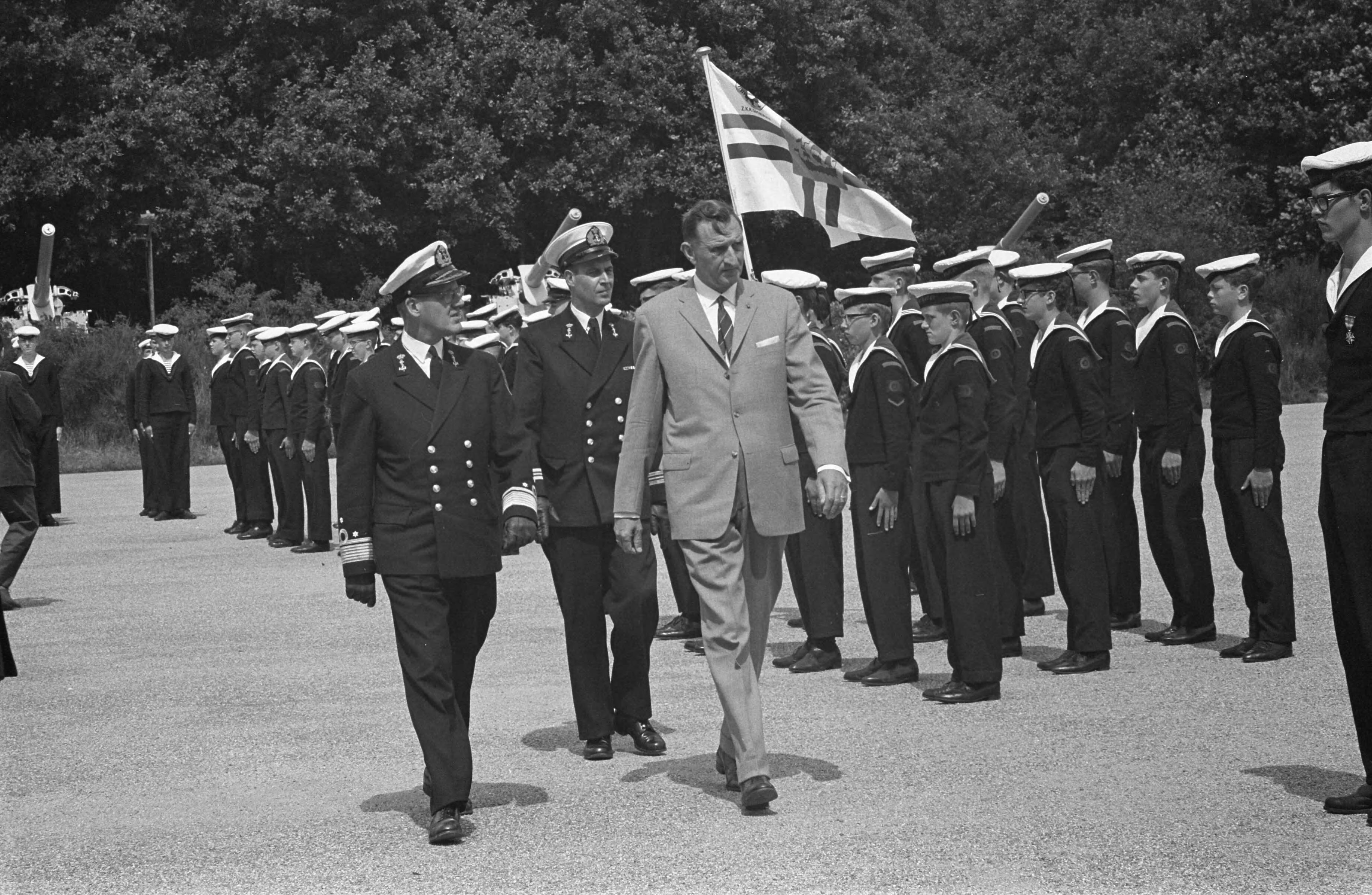 12,5 jarig jubileum van het Zeecadettenkorps — Zomerkamp van het Zeekadettencorps Nederland in het Marine Opleidingskamp te Hollandsche Rading bij Hilversum. Defilé t.g.v. 12,5 jarig bestaan. Inspectie door vice-admiraal A.J. van der Schatte Olivier en H. Harinkc, vice-voorzitter van de Koninklijke Nederlandsche Reedersvereniging — Foto: Fotograaf Onbekend / Anefo. Licentie: Set B: Rechtenvrij / Publiek Domein. Bron: Nationaal Archief. http://hdl.handle.net/10648/a9de7cca-d0b4-102d-bcf8-003048976d84