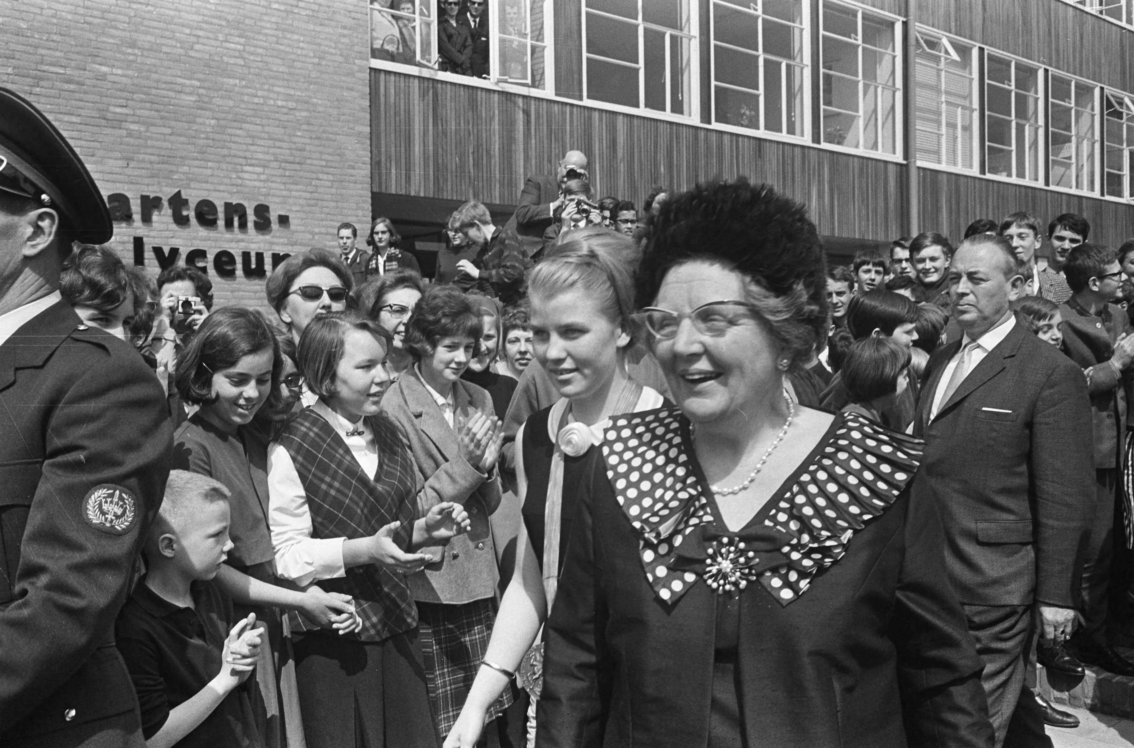 Fotocollectie Anefo — Koningin Juliana in Voorburg, Opening St. Maartenslyceum. De koningin loopt door een haag van scholieren — Foto: Koch, Eric / Anefo. Licentie: Set B: Rechtenvrij / Publiek Domein. Bron: Nationaal Archief. http://hdl.handle.net/10648/aae7467e-d0b4-102d-bcf8-003048976d84
