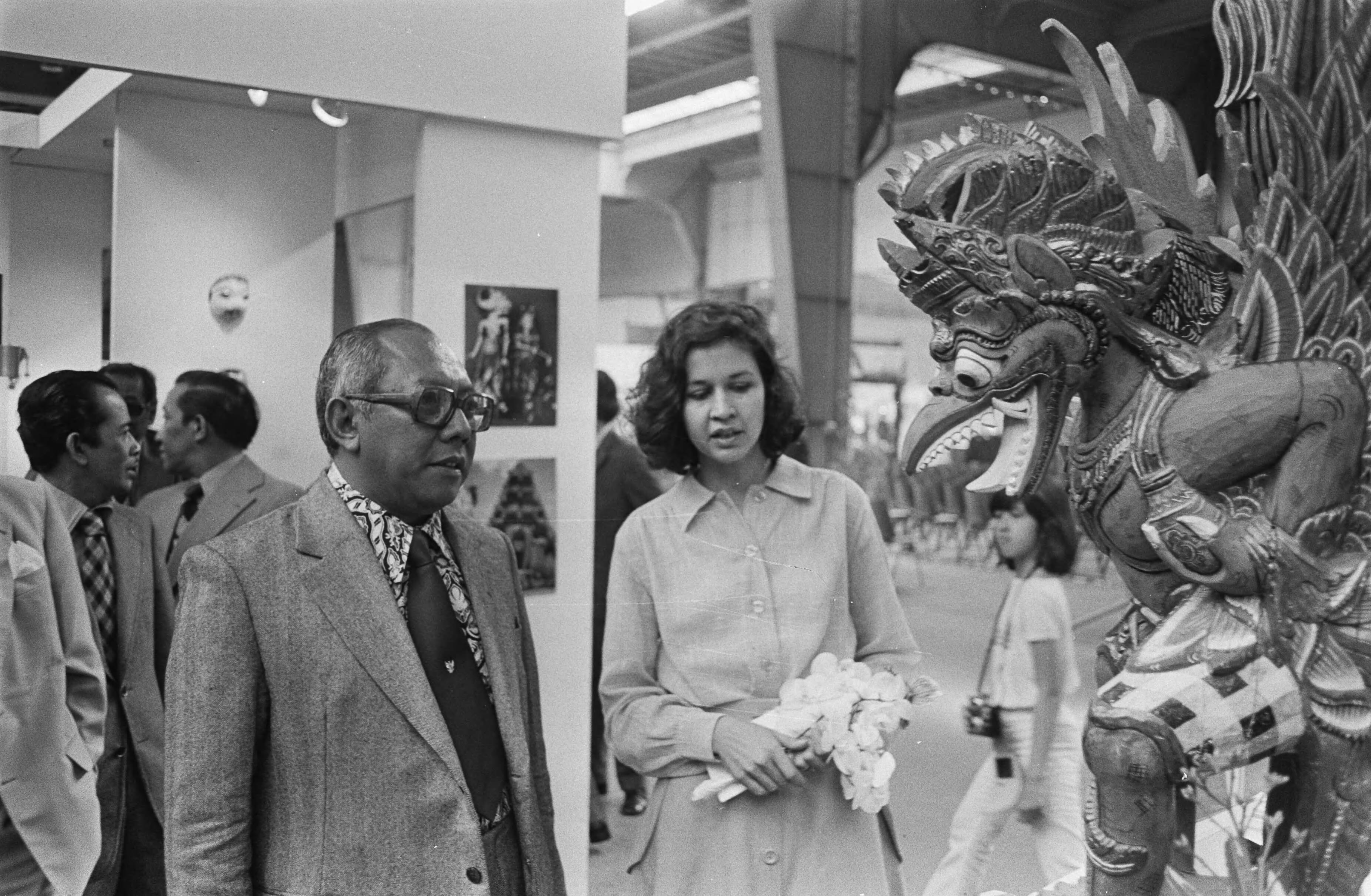 Fotocollectie Anefo — Pasar Malam in Houtrusthallen Den Haag ; ambassadeur Sutopo Yuwono Projohandoko bekijkt samen met organisatrice E. Boon een beeld — Foto: Bogaerts, Rob / Anefo. Licentie: Set B: Rechtenvrij / Publiek Domein. Bron: Nationaal Archief. http://hdl.handle.net/10648/ad7a0dd6-d0b4-102d-bcf8-003048976d84