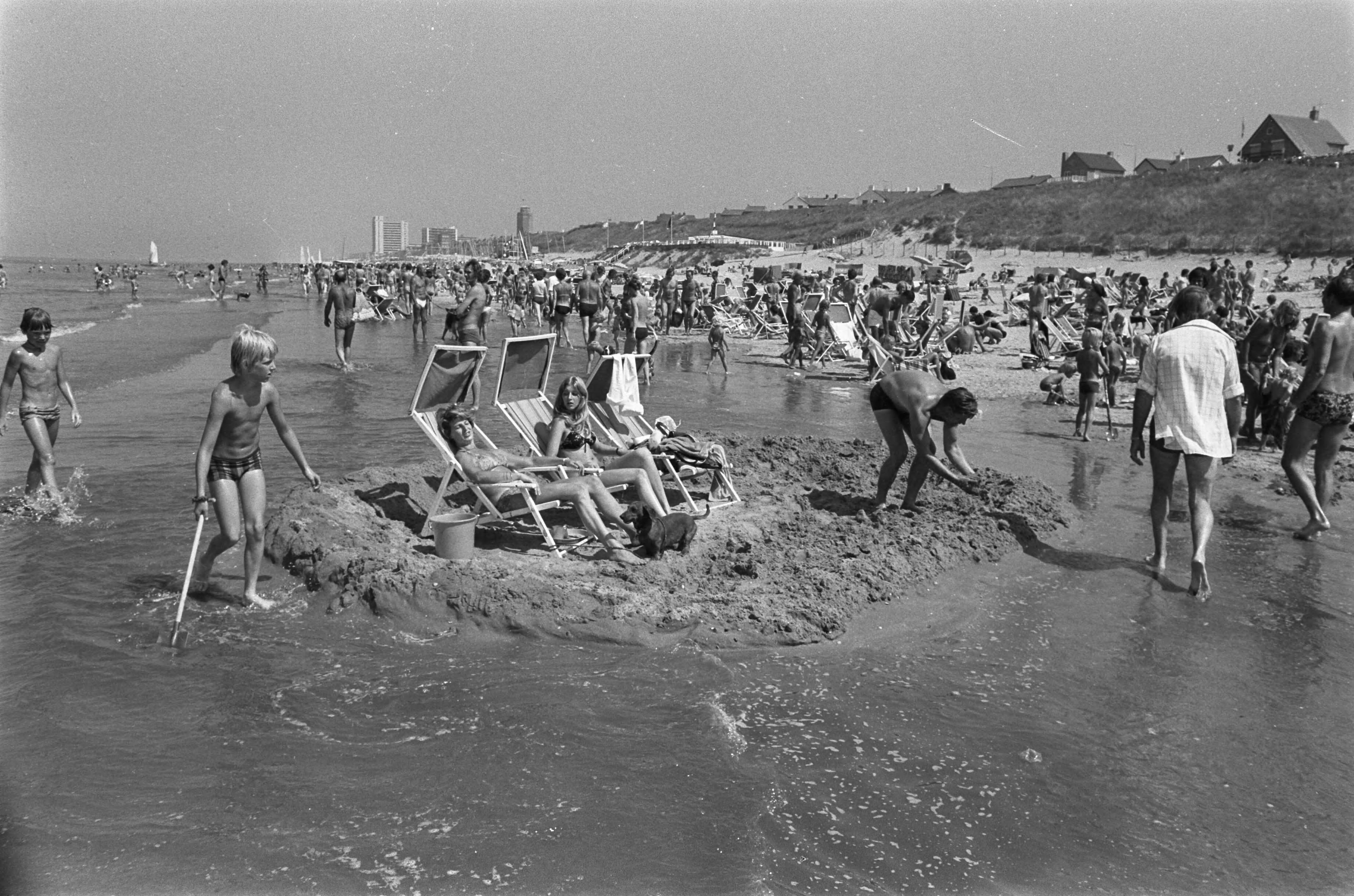 Warmste zomerdag — Zonnende mensen op een zelfgemaakt eilandje in Zandvoort — Foto: Verhoeff, Bert / Anefo. Licentie: Set B: Rechtenvrij / Publiek Domein. Bron: Nationaal Archief. http://hdl.handle.net/10648/ac6edfca-d0b4-102d-bcf8-003048976d84
