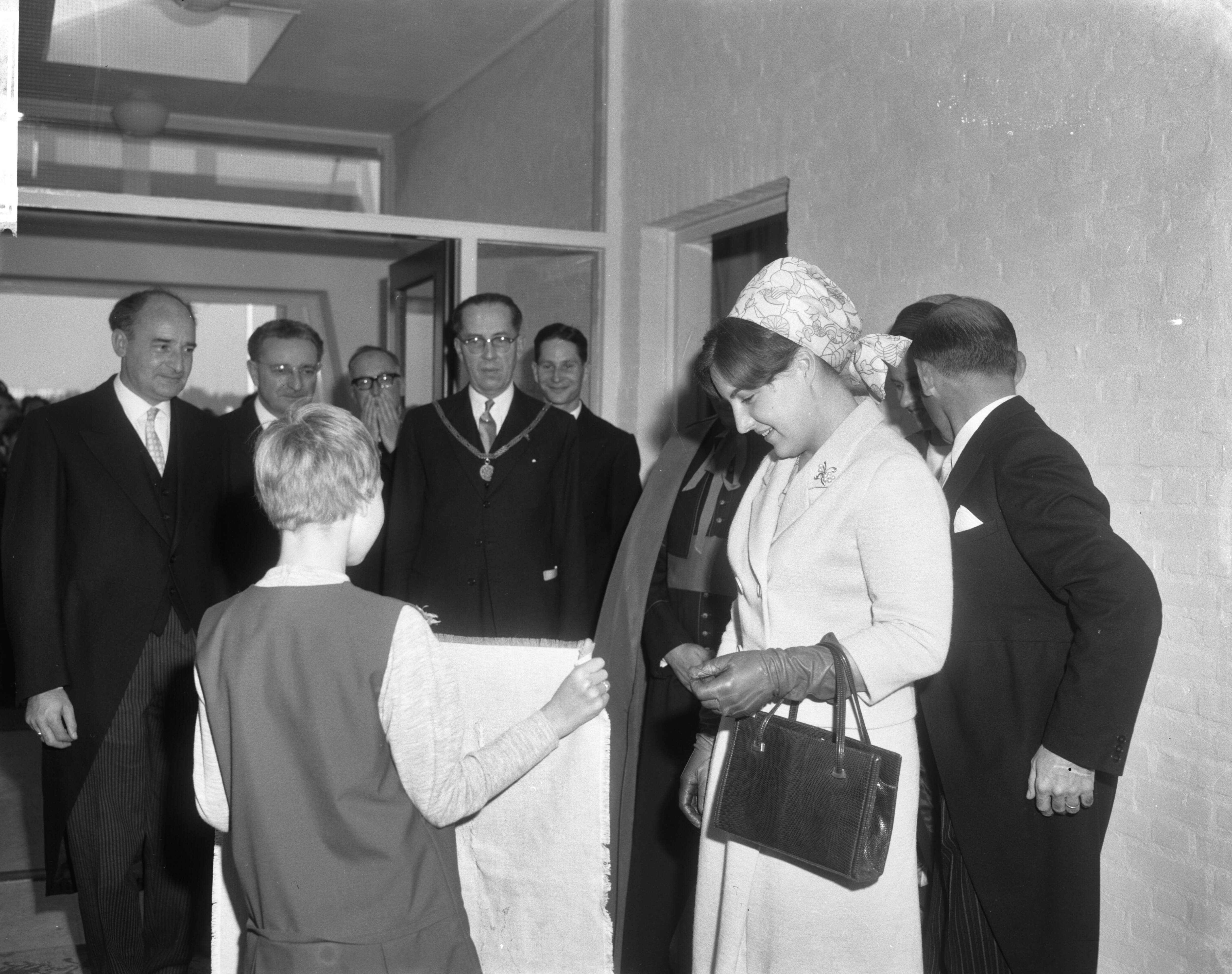 Fotocollectie Anefo — Prinses Margriet heeft in Maastricht de BLO-school Jan Baptist geopend. Een der pupillen bied een geschenk aan, een door haarzelf vervaardigde geborduurde wandlap — Foto: Bilsen, Joop van / Anefo. Licentie: Set B: Rechtenvrij / Publiek Domein. Bron: Nationaal Archief. http://hdl.handle.net/10648/aac43f9e-d0b4-102d-bcf8-003048976d84