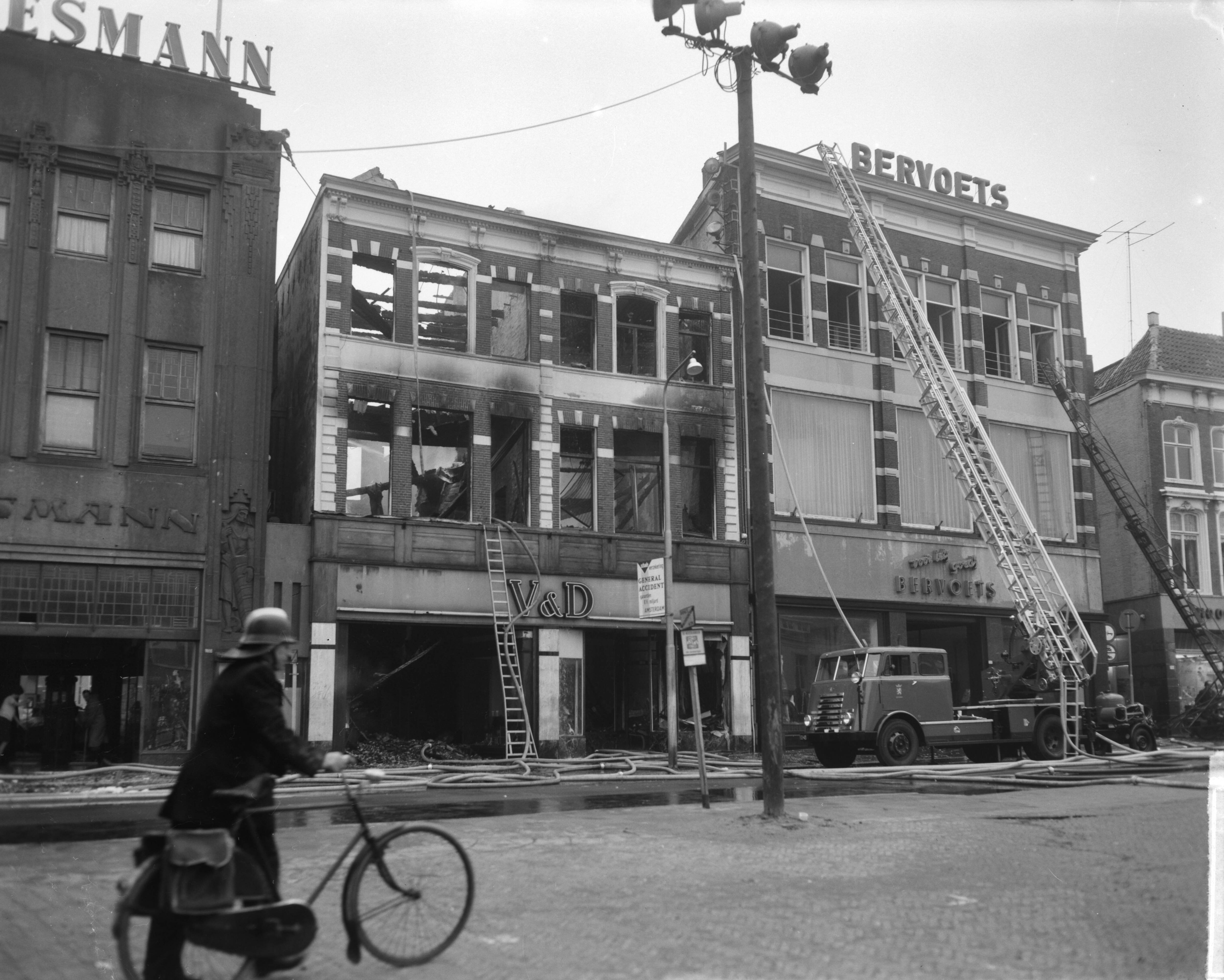 Fotocollectie Anefo — Brand bij V&D te Leeuwarden. Onbeschadigde confectie wordt in veiligheid gebracht — Foto: Bilsen, Joop van / Anefo. Licentie: Set B: Rechtenvrij / Publiek Domein. Bron: Nationaal Archief. http://hdl.handle.net/10648/aa2ed530-d0b4-102d-bcf8-003048976d84