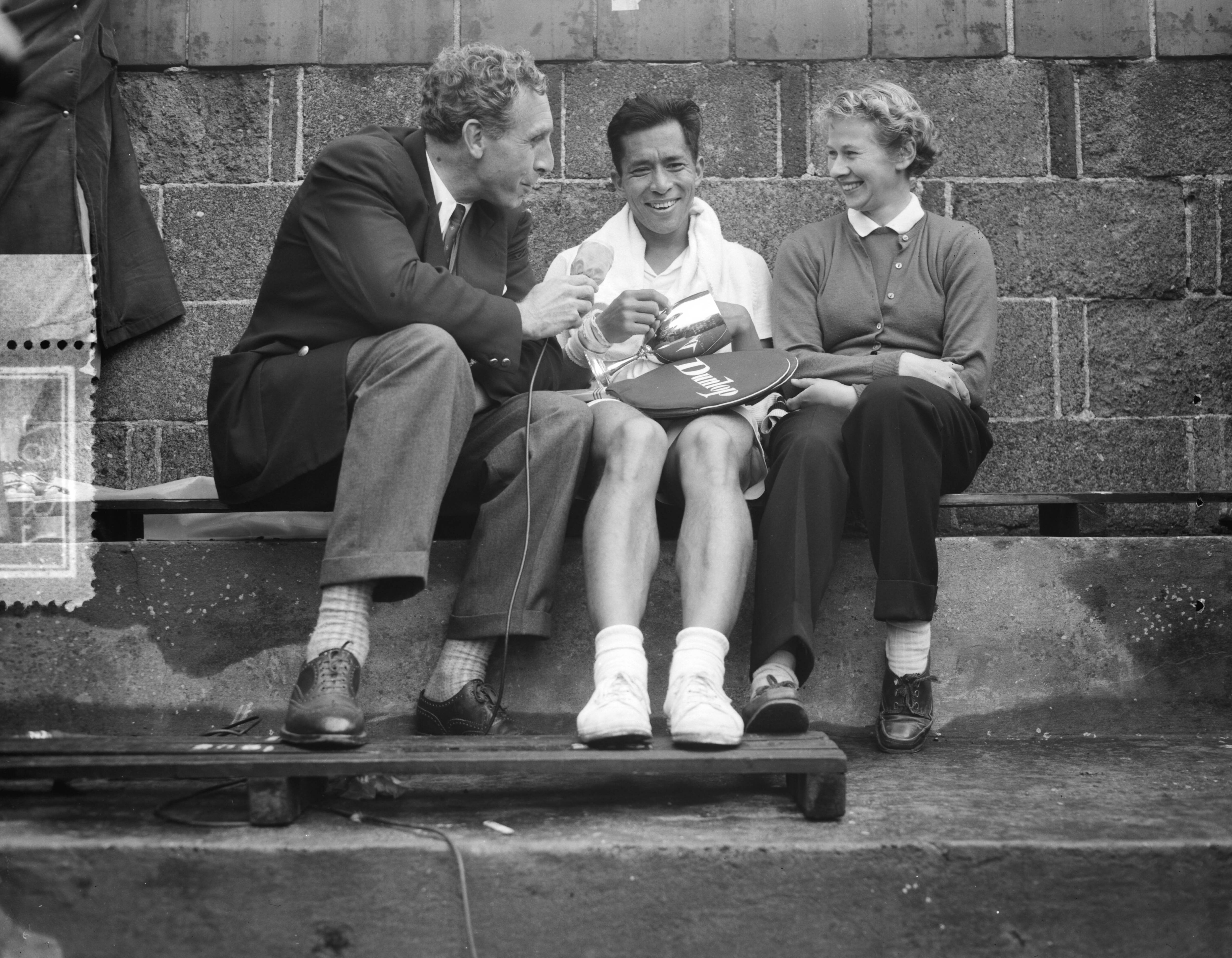 Fotocollectie Anefo — Nederlandse tenniskampioenschappen op de METS-banen. Winnaars heren en dames enkelspel Lex Karamoy en Jopie Roos-van de Wal worden geinterviewd door televisie-verslaggever Hans van Swol — Foto: Fotograaf Onbekend / Anefo. Licentie: Set B: Rechtenvrij / Publiek Domein. Bron: Nationaal Archief. http://hdl.handle.net/10648/ad77d296-d0b4-102d-bcf8-003048976d84