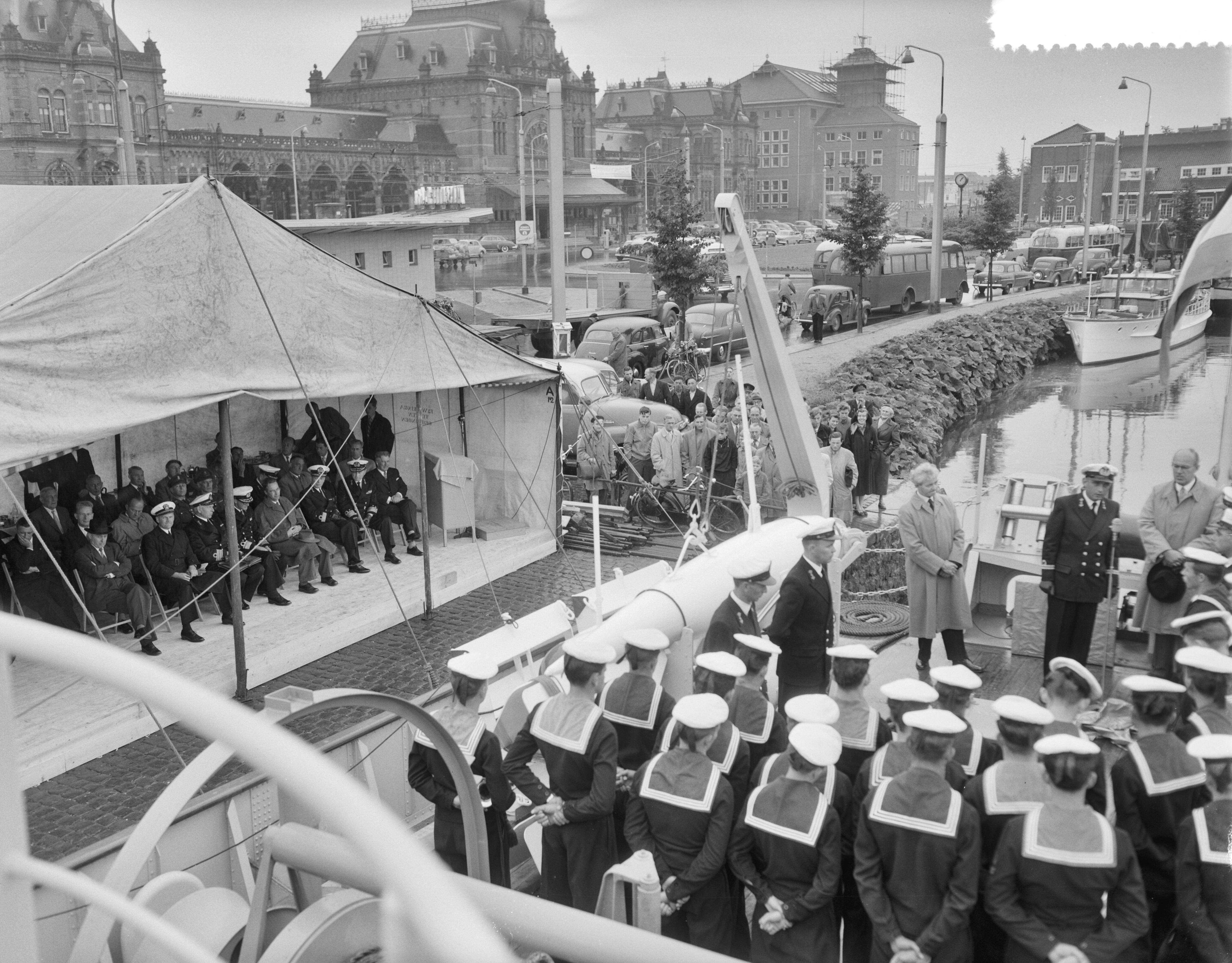 Overdracht en indienststelling van de kustmijnenveger Hr. Ms. "Lochem" in het Verbindingskanaal te Groningen — Overdracht en indienststelling van de kustmijnenveger Hr. Ms. "Lochem" in het Verbindingskanaal te Groningen. Op het achterdek spreekt de commandant van het schip, luitenant-ter-zee 2e klasse D. Lindner — Foto: Behrens, Herbert F. / Anefo. Licentie: Set B: Rechtenvrij / Publiek Domein. Bron: Nationaal Archief. http://hdl.handle.net/10648/a94bb566-d0b4-102d-bcf8-003048976d84
