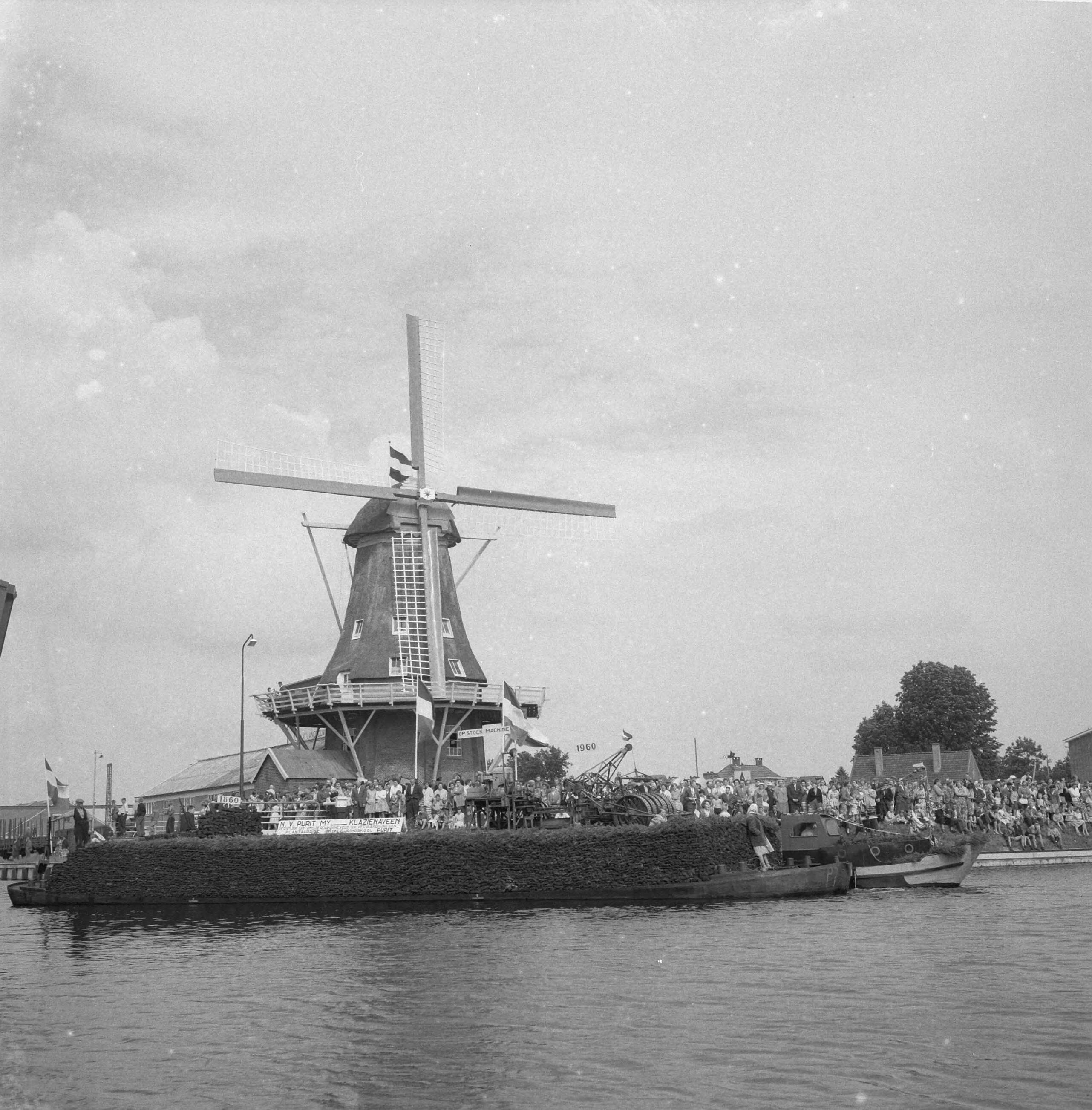 Burgemeester Van Hall bezoekt Nieuw Amsterdam, dat 100 jaar bestaat — Burgemeester Van Hall bezoekt Nieuw Amsterdam, dat 100 jaar bestaat. Turfschip vaart door brug. Op achtergrond molen — Foto: Rossem, Wim van / Anefo. Licentie: Set B: Rechtenvrij / Publiek Domein. Bron: Nationaal Archief. http://hdl.handle.net/10648/a9b75276-d0b4-102d-bcf8-003048976d84