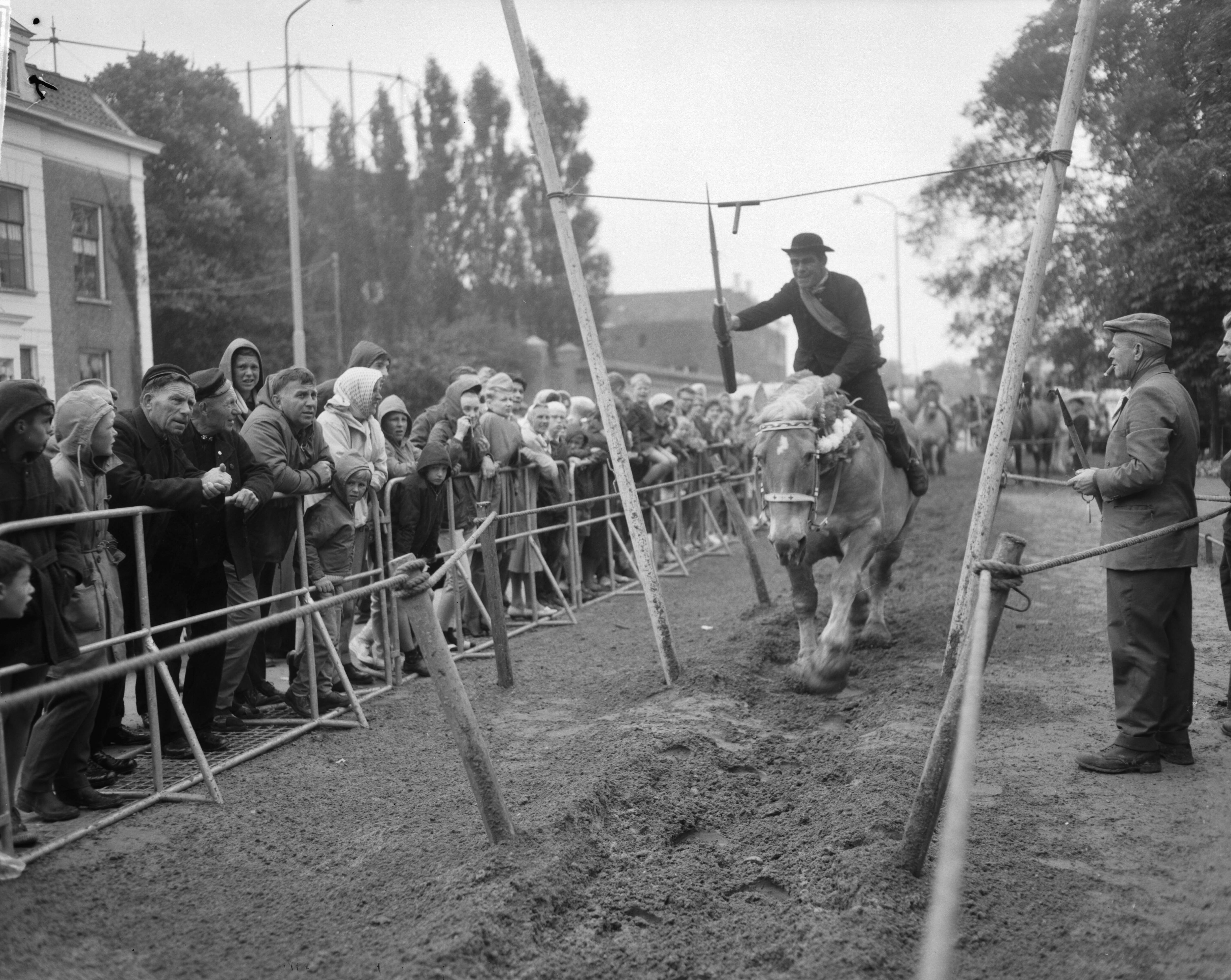Fotocollectie Anefo — Ringrijderijen op het Molenwater te Middelburg. Een deelnemer tijdens het ringsteken — Foto: Bilsen, Joop van / Anefo. Licentie: Set B: Rechtenvrij / Publiek Domein. Bron: Nationaal Archief. http://hdl.handle.net/10648/aa43613a-d0b4-102d-bcf8-003048976d84