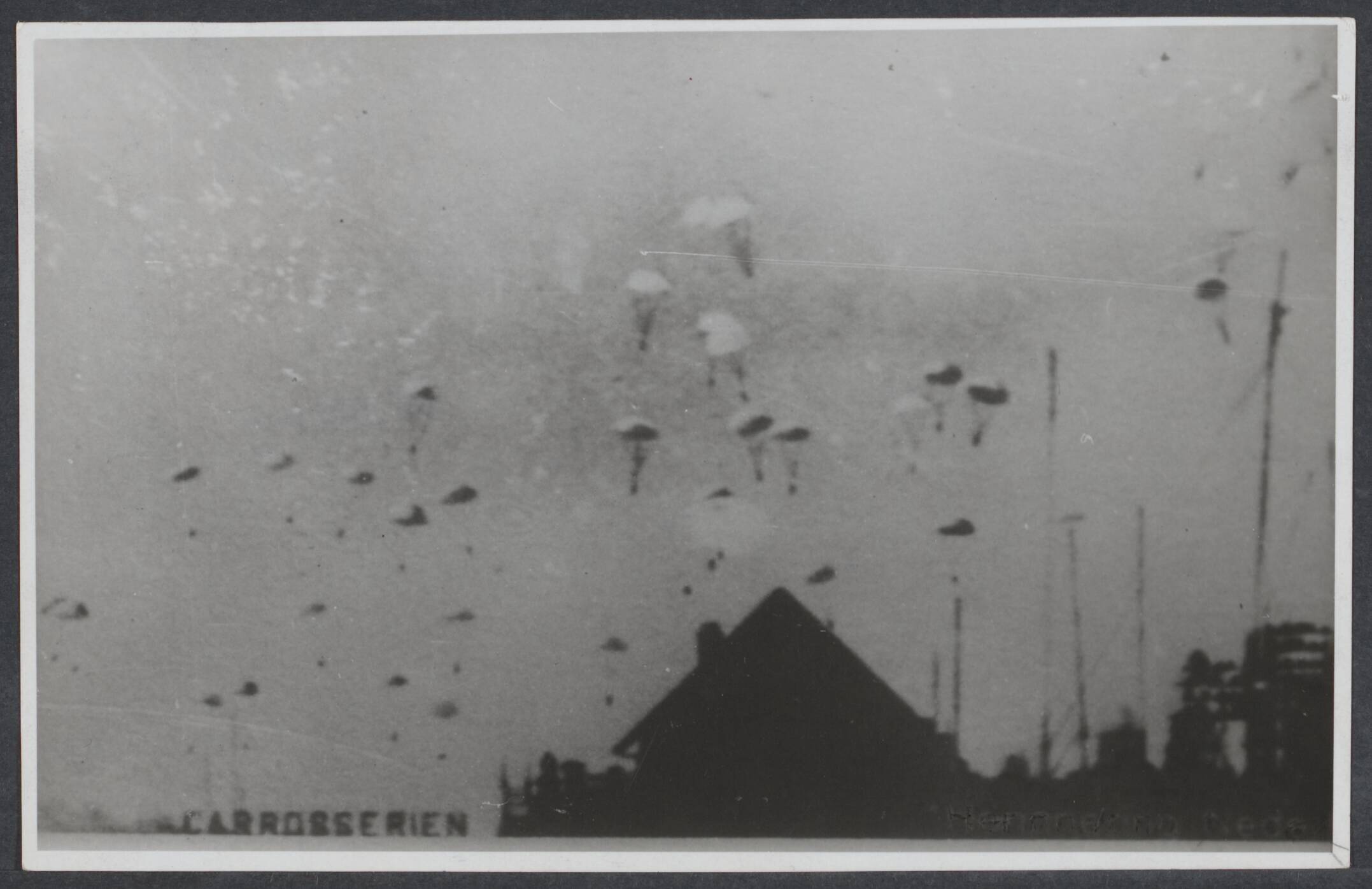 B. Nederlands Front - Meidagen '40. — Duitse parachutisten boven het Bezuidenhout in Den Haag — Foto: Onbekend / Publiek Domein of Rechtenvrij. Licentie: Set B: Rechtenvrij / Publiek Domein. Bron: Nationaal Archief. http://hdl.handle.net/10648/55b75ff1-cb61-a9b9-c890-c807148a0a39