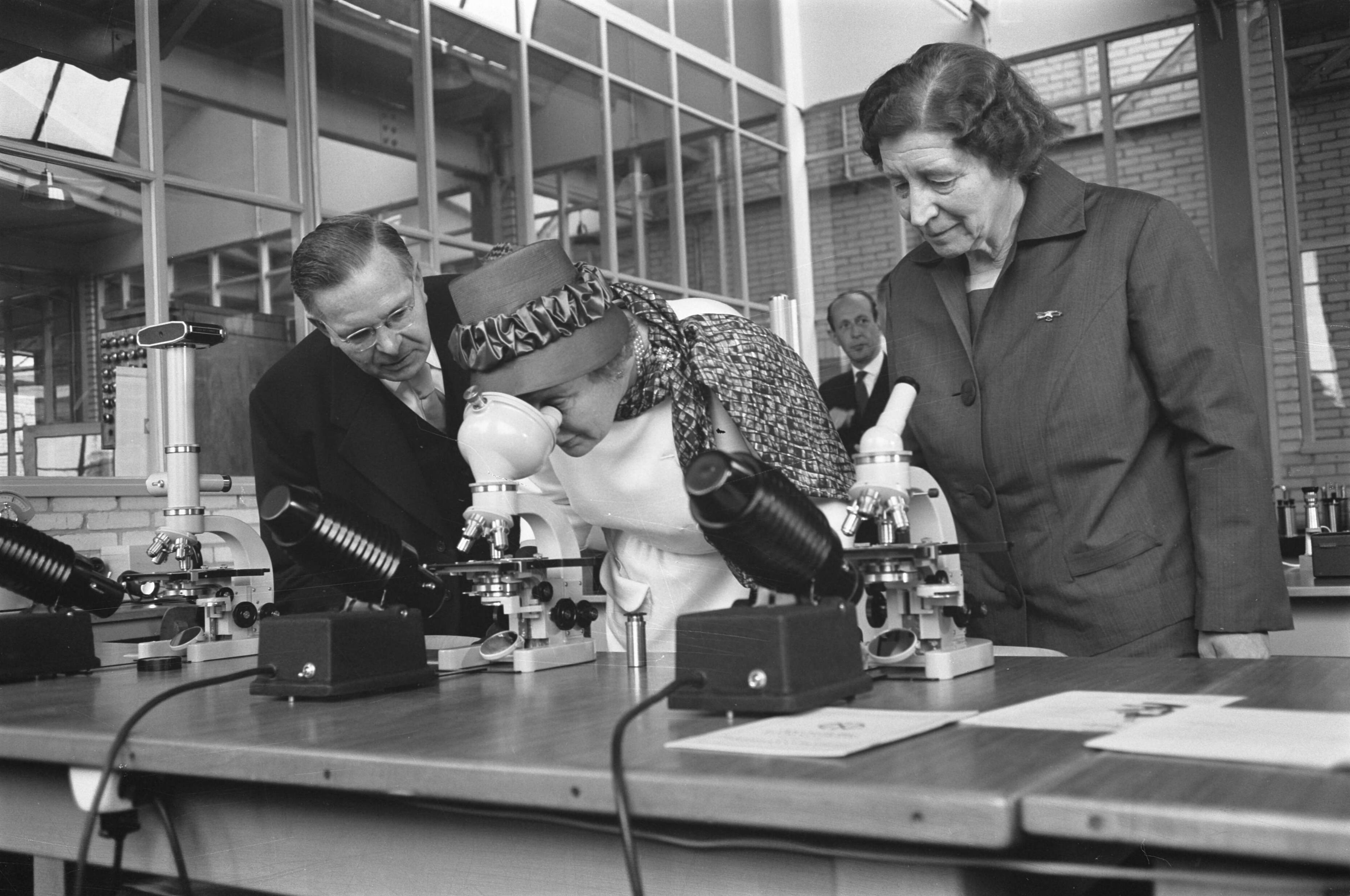 Bezoek koningin Juliana aan Zeist en omgeving — Bezoek koningin Juliana aan Zeist en omgeving. Koningin Juliana bezoekt de Nederlandsche Optiek- en Instrumentenfabriek Dr. C. Bleeker N.V. (Nedoptifa) in Zeist, rechts oprichtster en directrice Caroline Bleeker en links mededirecteur G. Willemse — Foto: Pot, Harry / Anefo. Licentie: Set B: Rechtenvrij / Publiek Domein. Bron: Nationaal Archief. http://hdl.handle.net/10648/a9d73910-d0b4-102d-bcf8-003048976d84