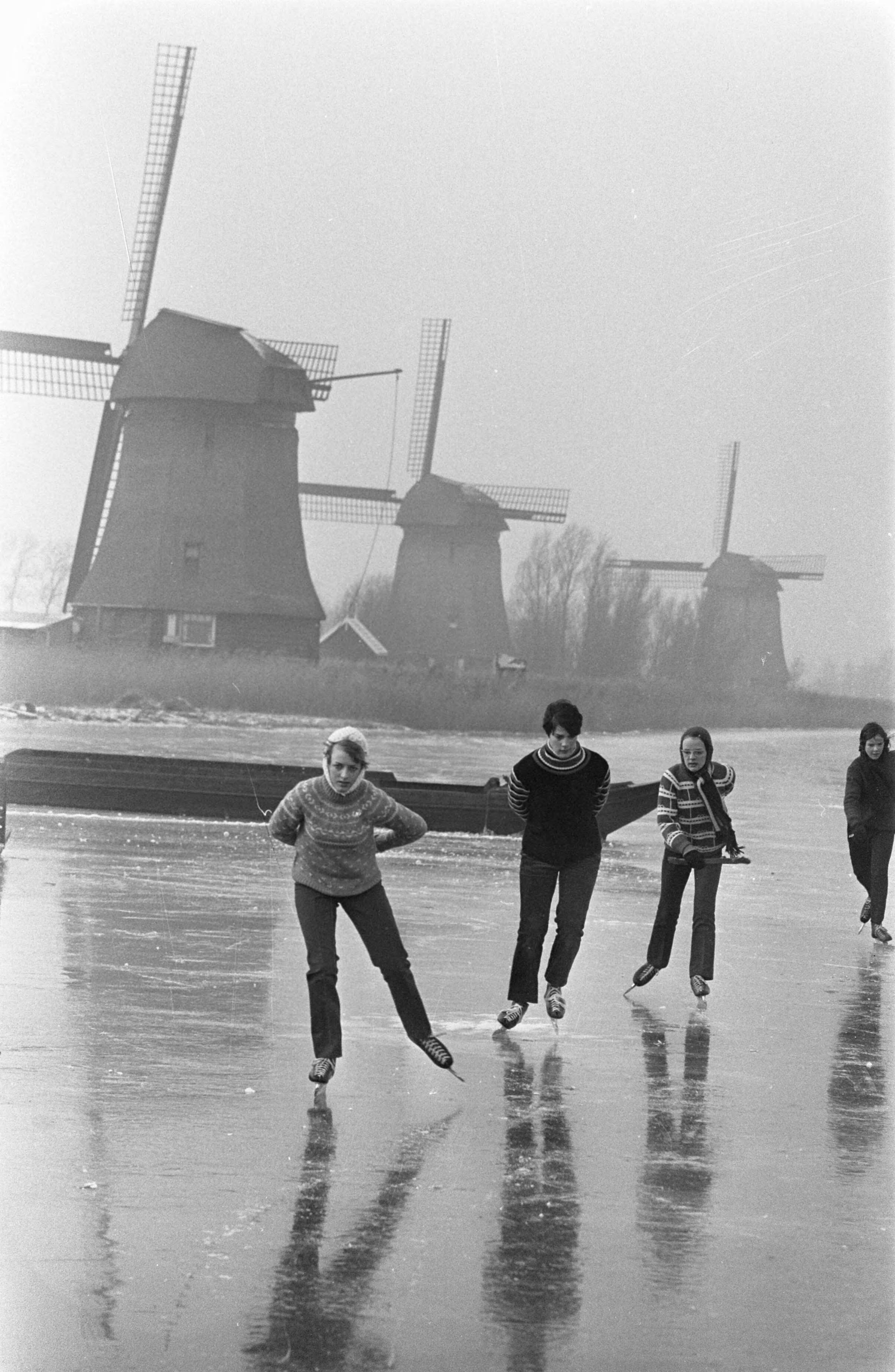 Fotocollectie Anefo — Schaatsers op de ringvaart van polder De Schermer bij Rustenburg. Op achtergrond een drietal strijkmolens — Foto: Kroon, Ron / Anefo. Licentie: Set B: Rechtenvrij / Publiek Domein. Bron: Nationaal Archief. http://hdl.handle.net/10648/ab581e58-d0b4-102d-bcf8-003048976d84